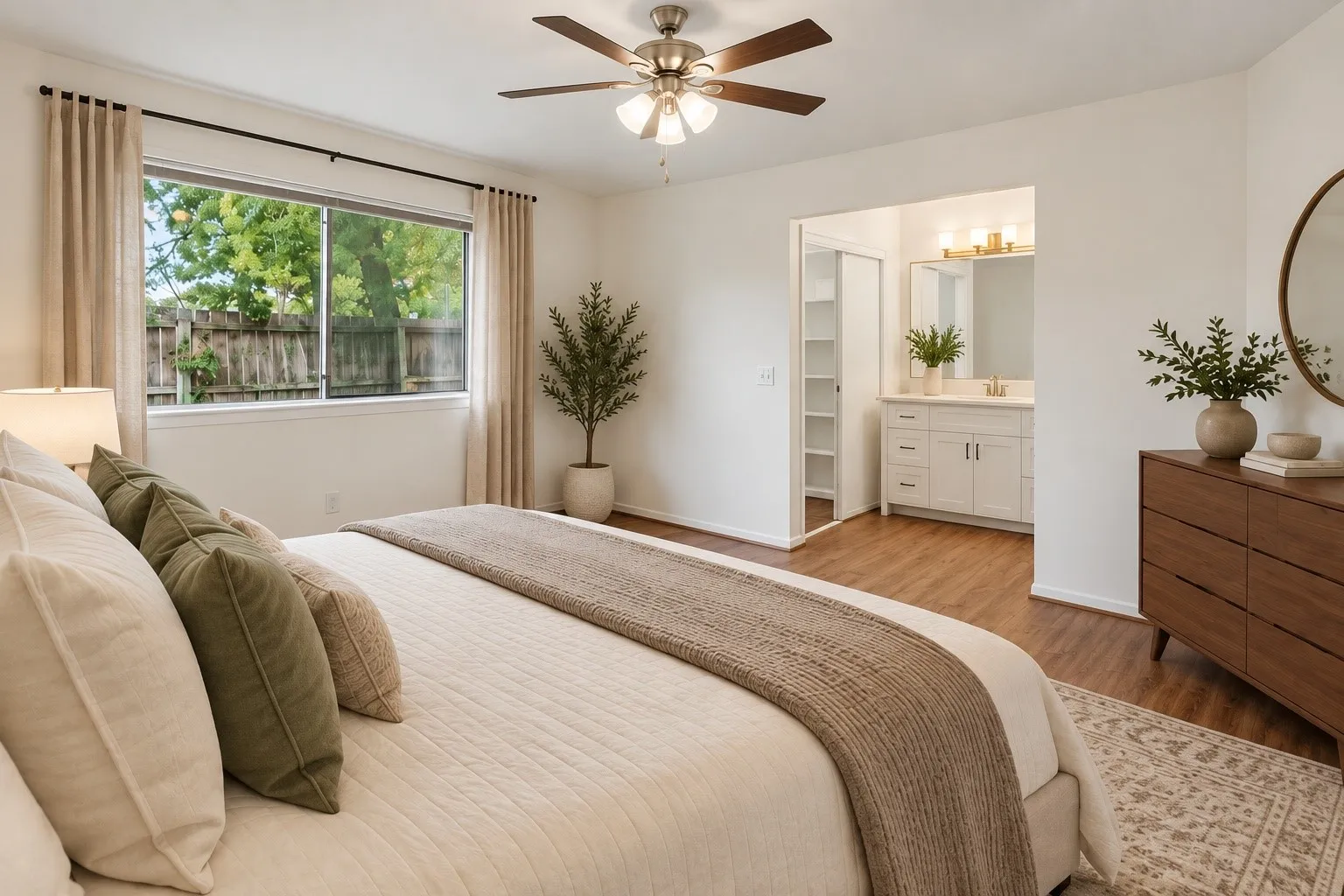 Primary bedroom with wood-finish flooring, a ceiling fan, and large window