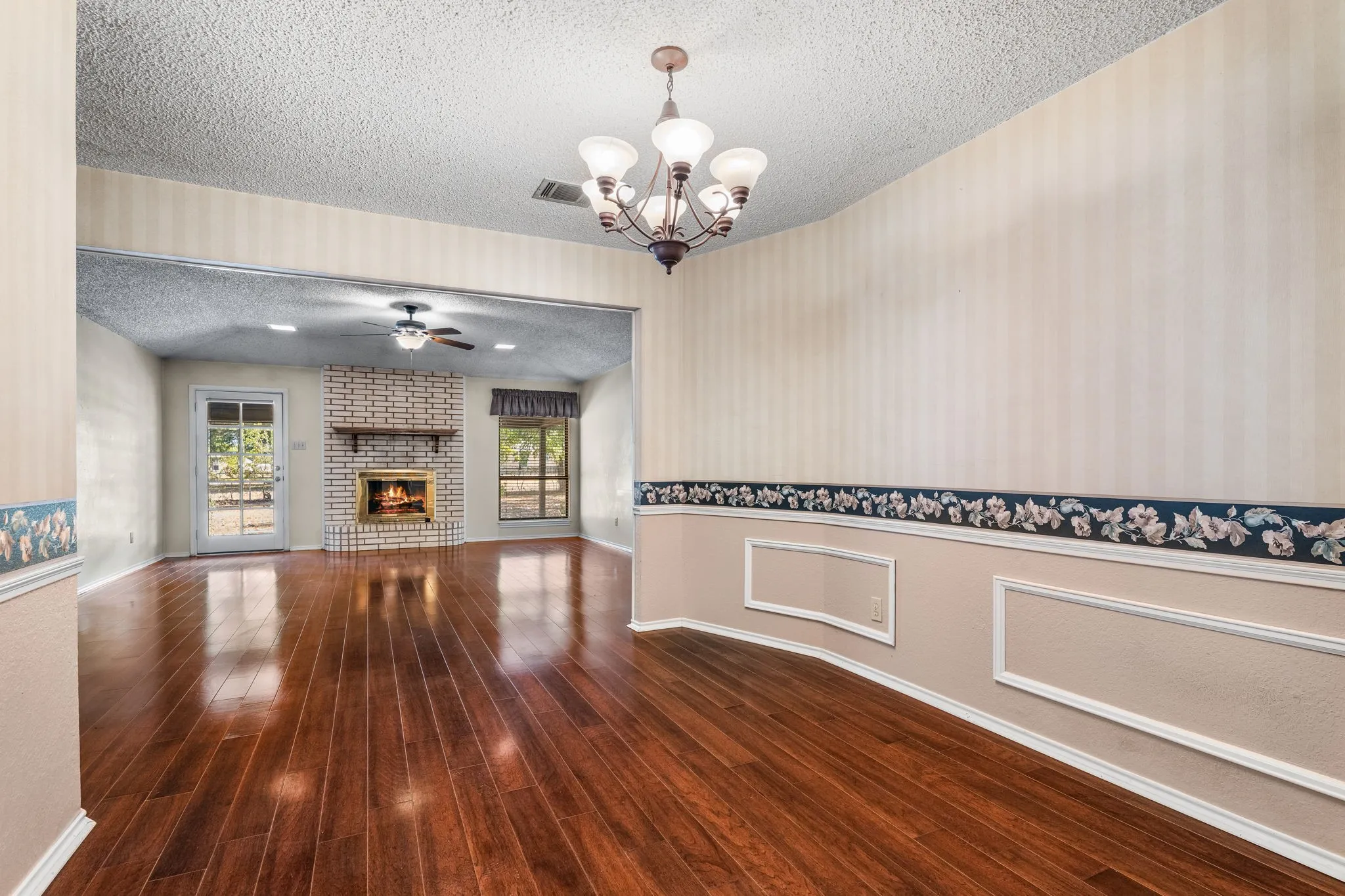 Hardwood-style flooring throughout, with a brick fireplace and mantel