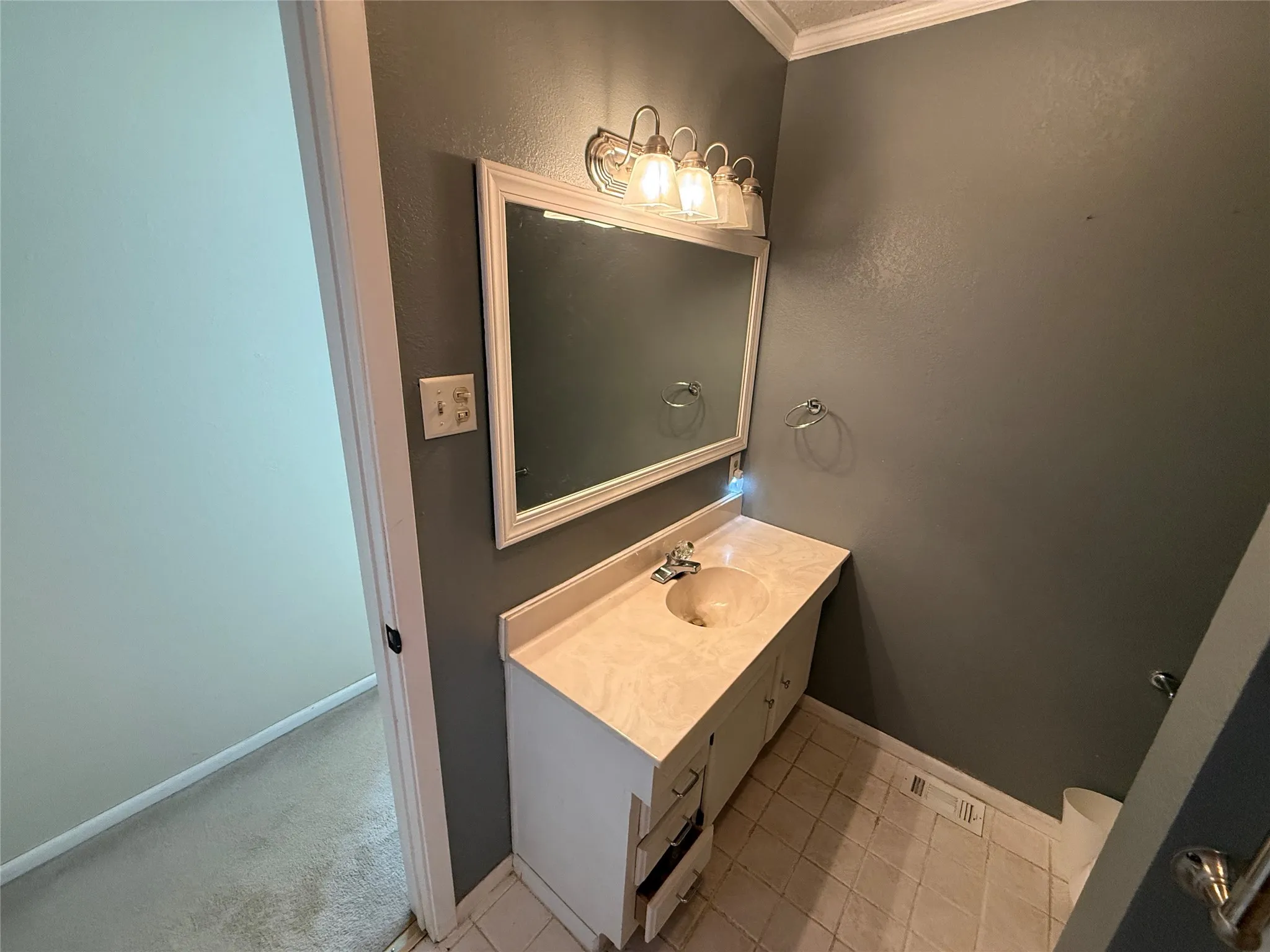 White vanity with integrated sink, framed mirror, and chrome light fixture