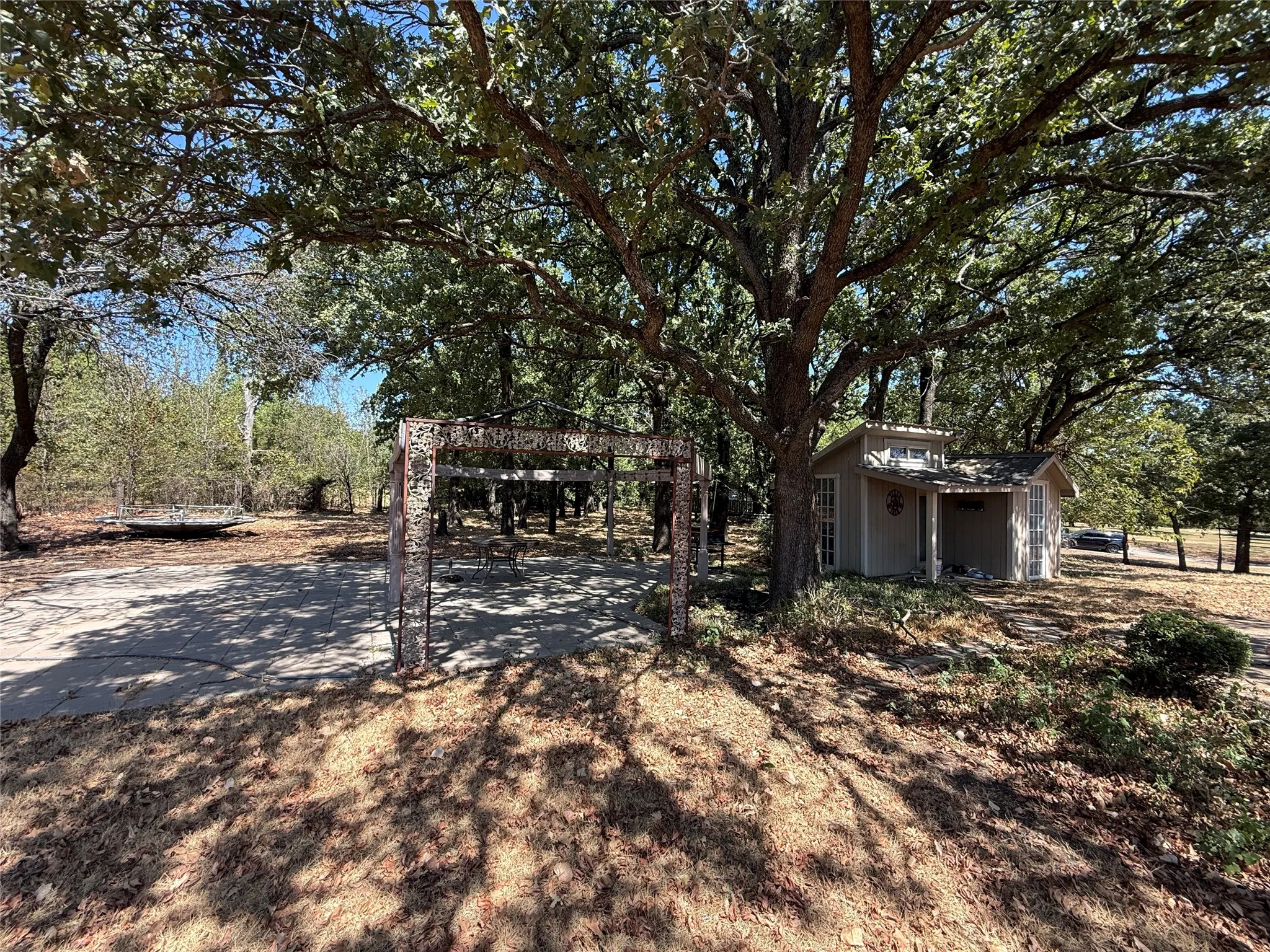 Detached auxiliary structure with a covered porch, set among mature trees
