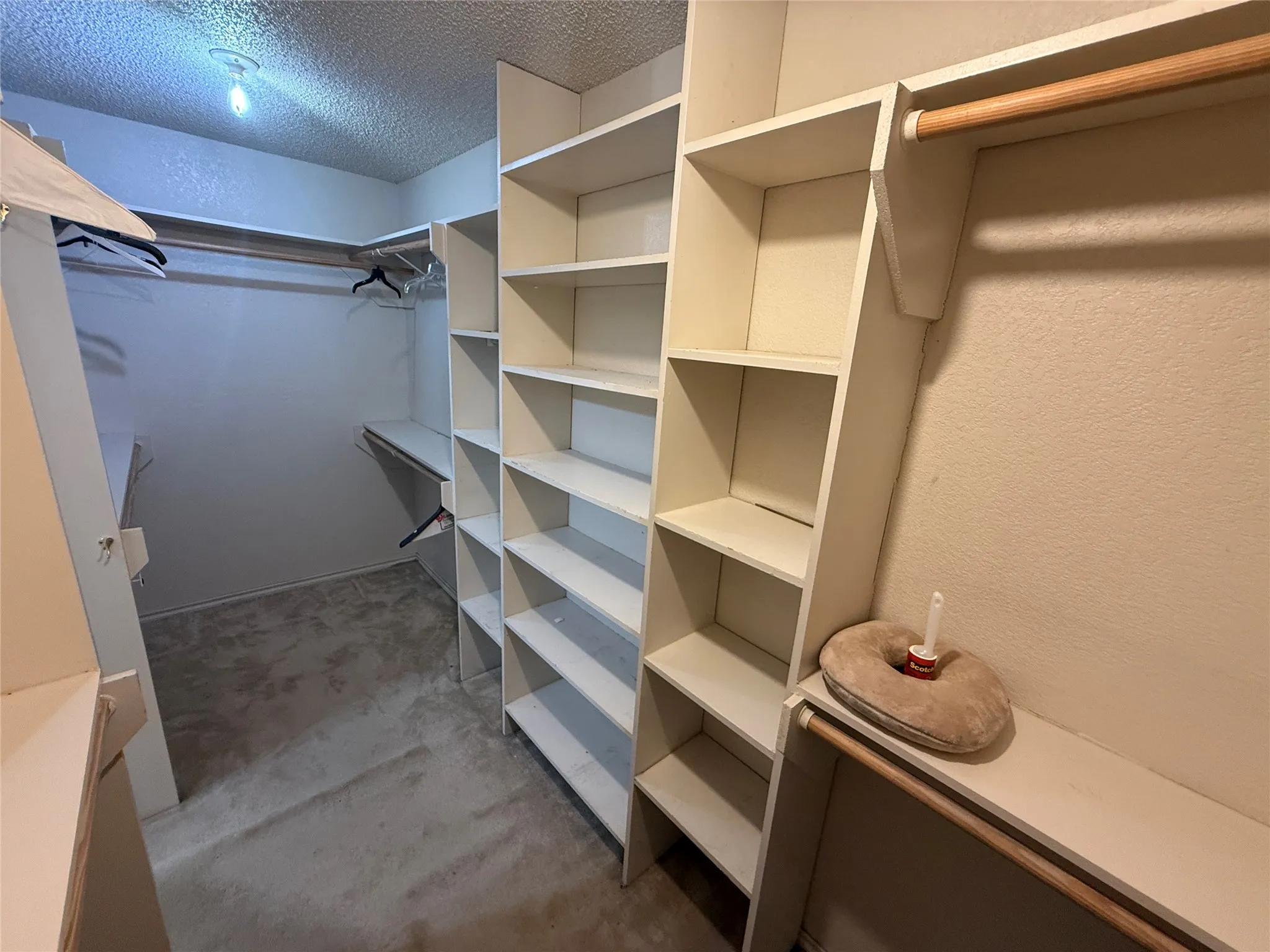 Custom closet organization system with extensive shelving, multiple hanging rods, and plush carpeting