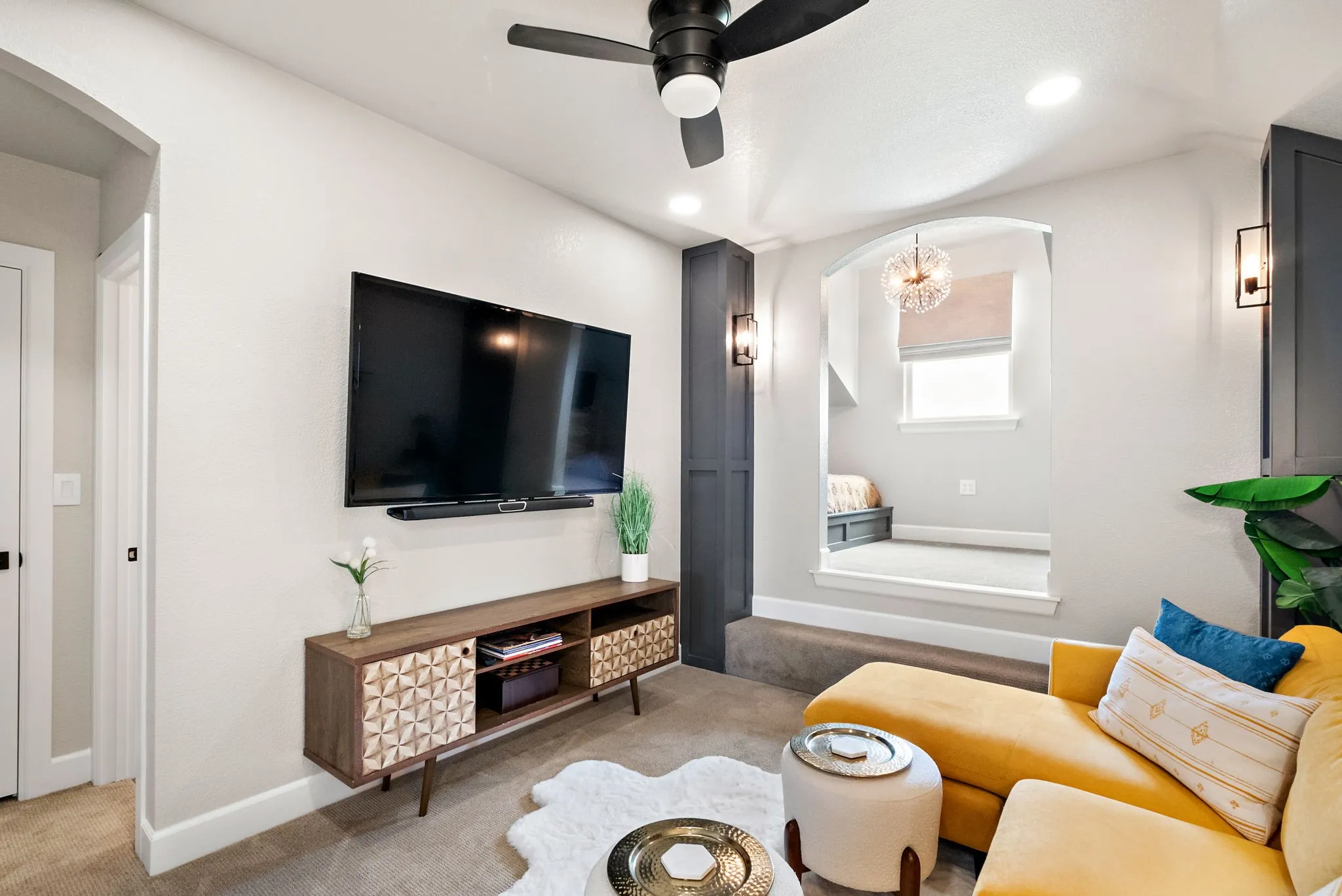 Recessed lighting, ceiling fan, and wall-mounted sconces illuminate this space