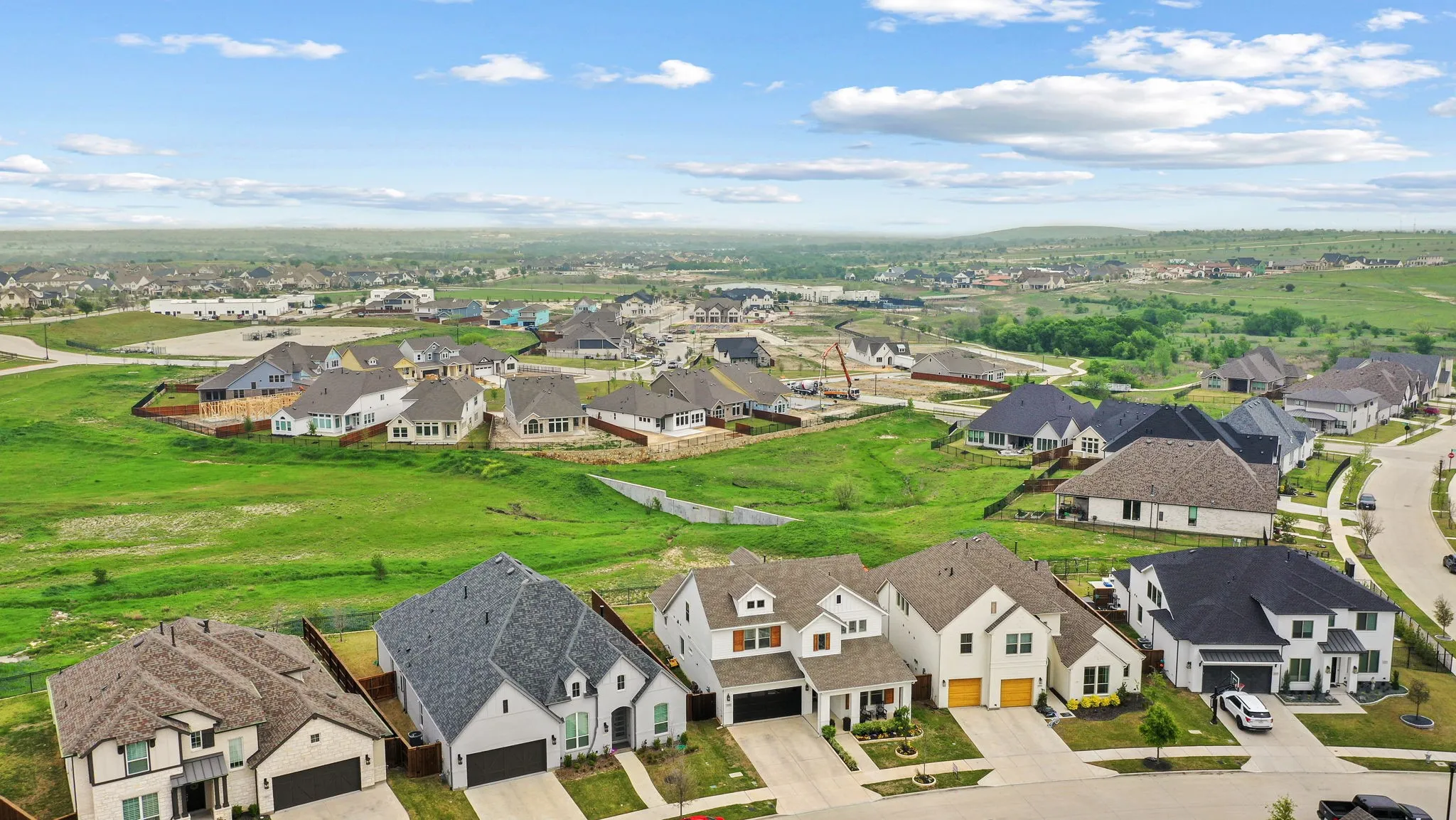 Expansive neighborhood development featuring a variety of architectural styles, paved streets, and green spaces