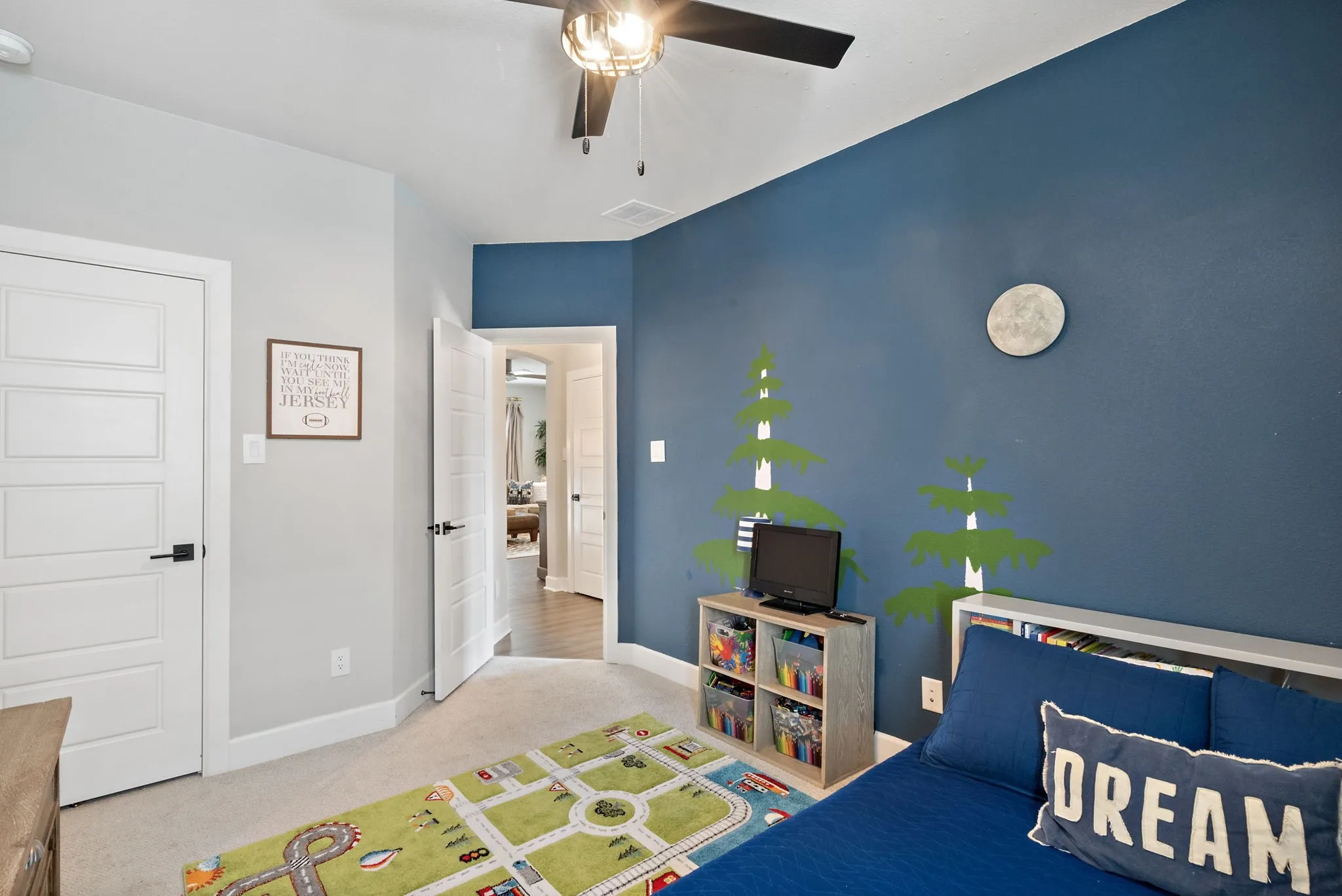 Carpeted room with a ceiling fan and light fixture