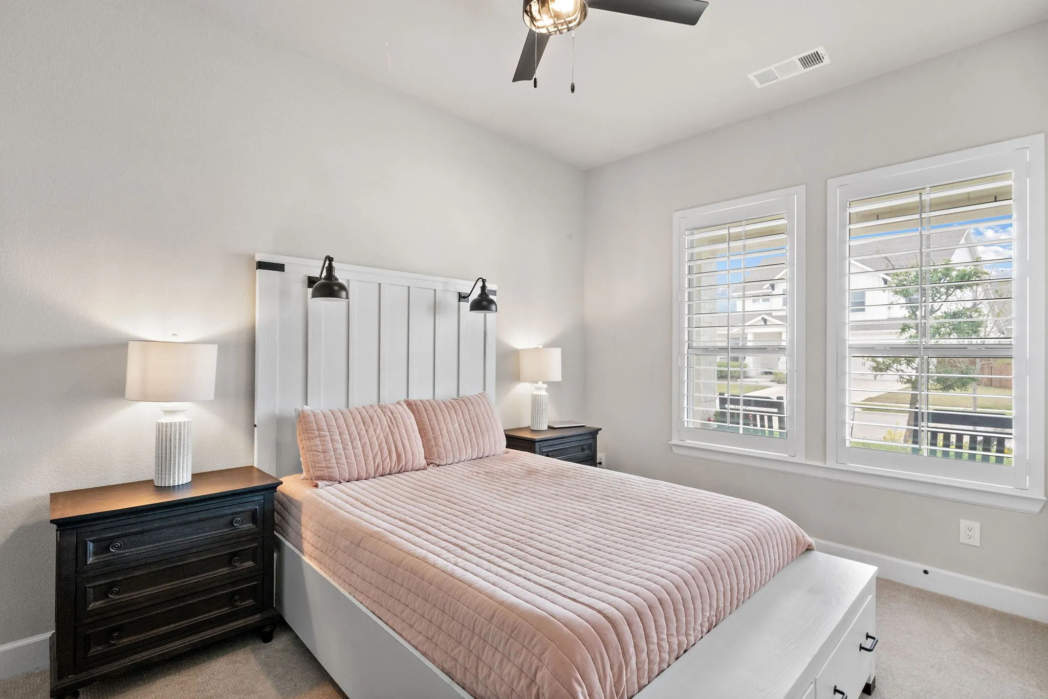 Recessed lighting, ceiling fan with integrated light, dual windows with plantation shutters, and light gray wall paint