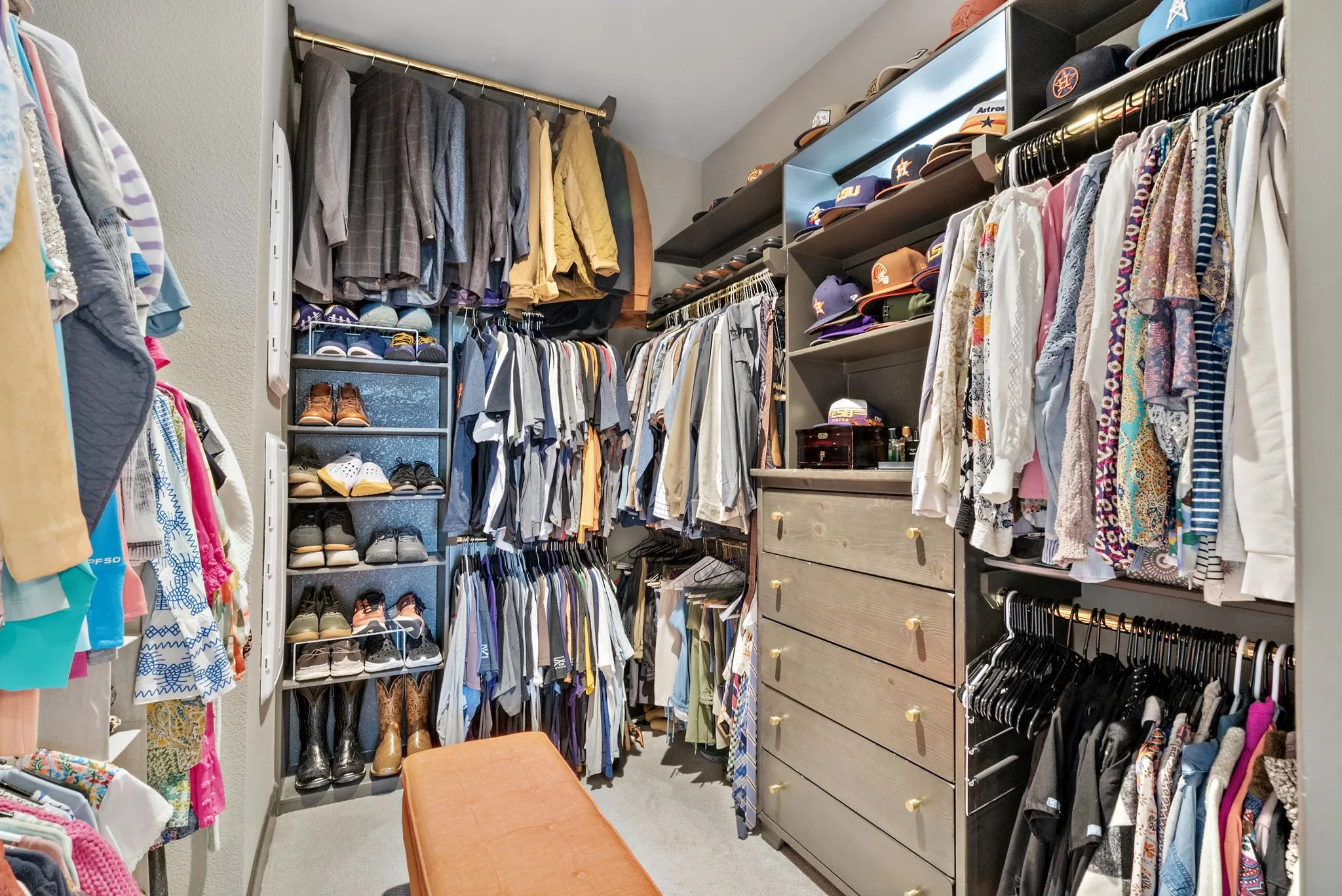 Custom closet system featuring built-in shelving, hanging rods, and a five-drawer dresser