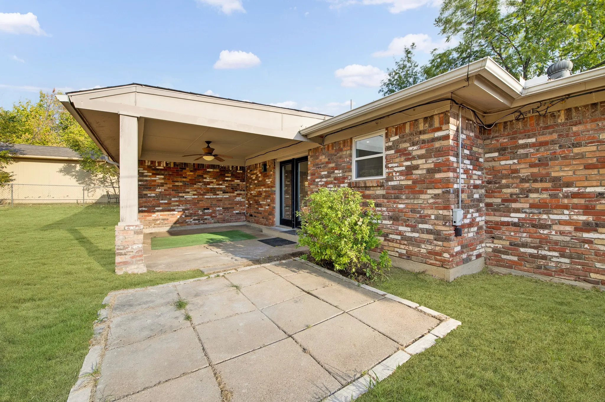 Brick exterior with a covered patio, recessed lighting, and a ceiling fan