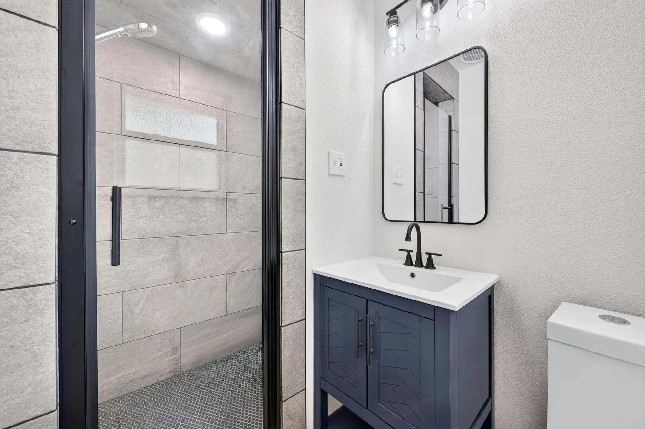 Glass-enclosed shower with tiled walls and a built-in niche