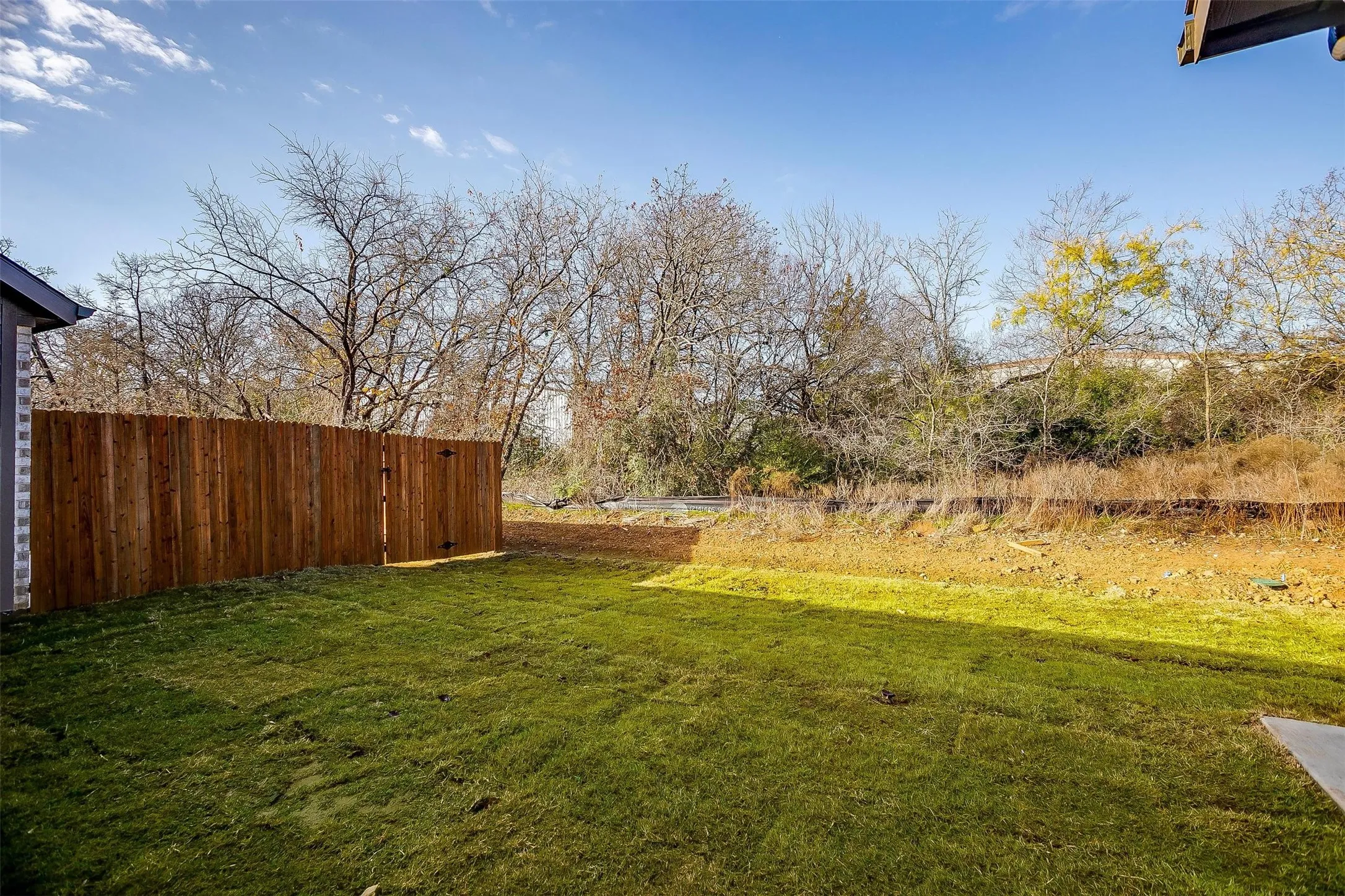 Expansive backyard featuring a manicured lawn and privacy fencing