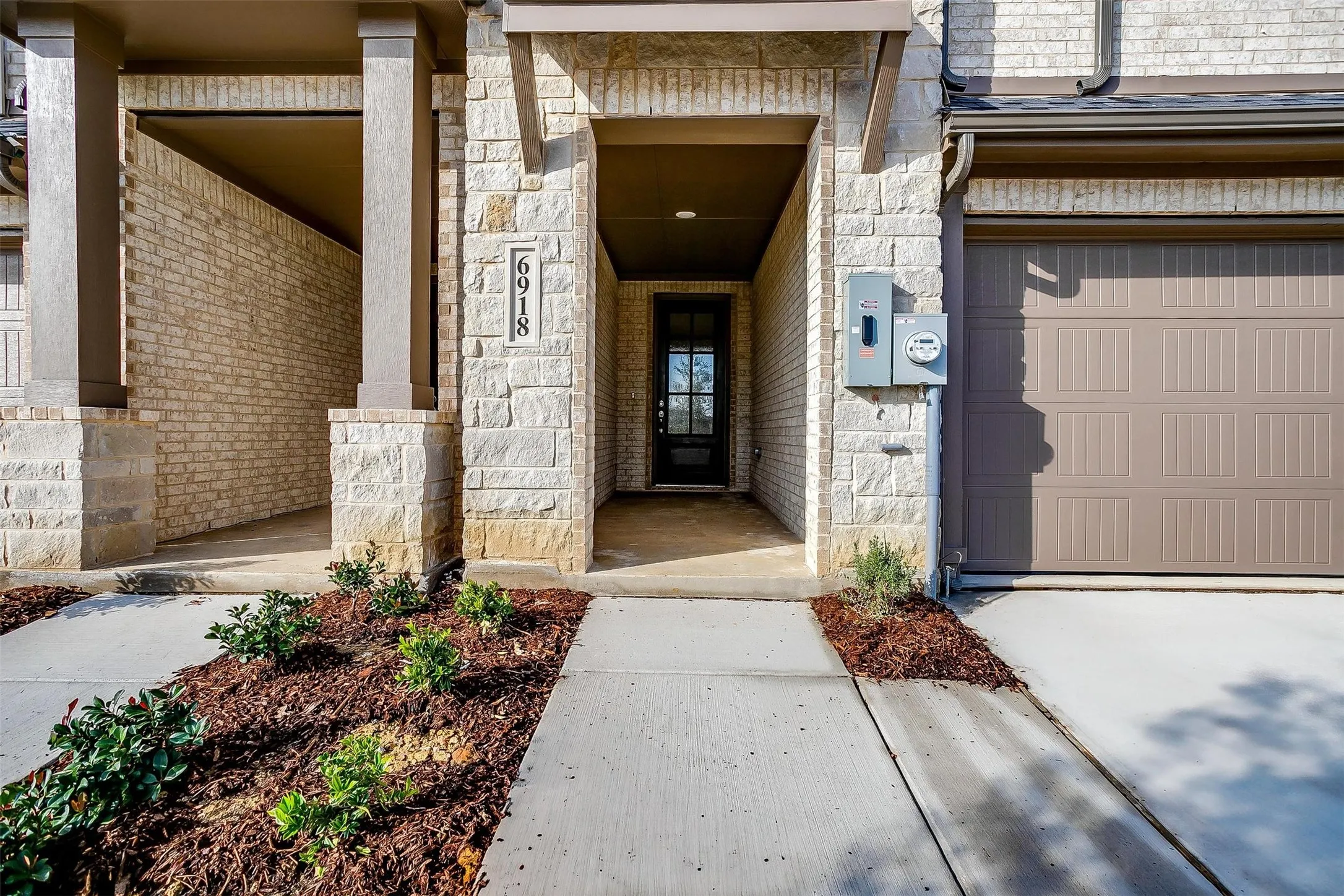 Stone facade with an integrated single-car garage and covered entry
