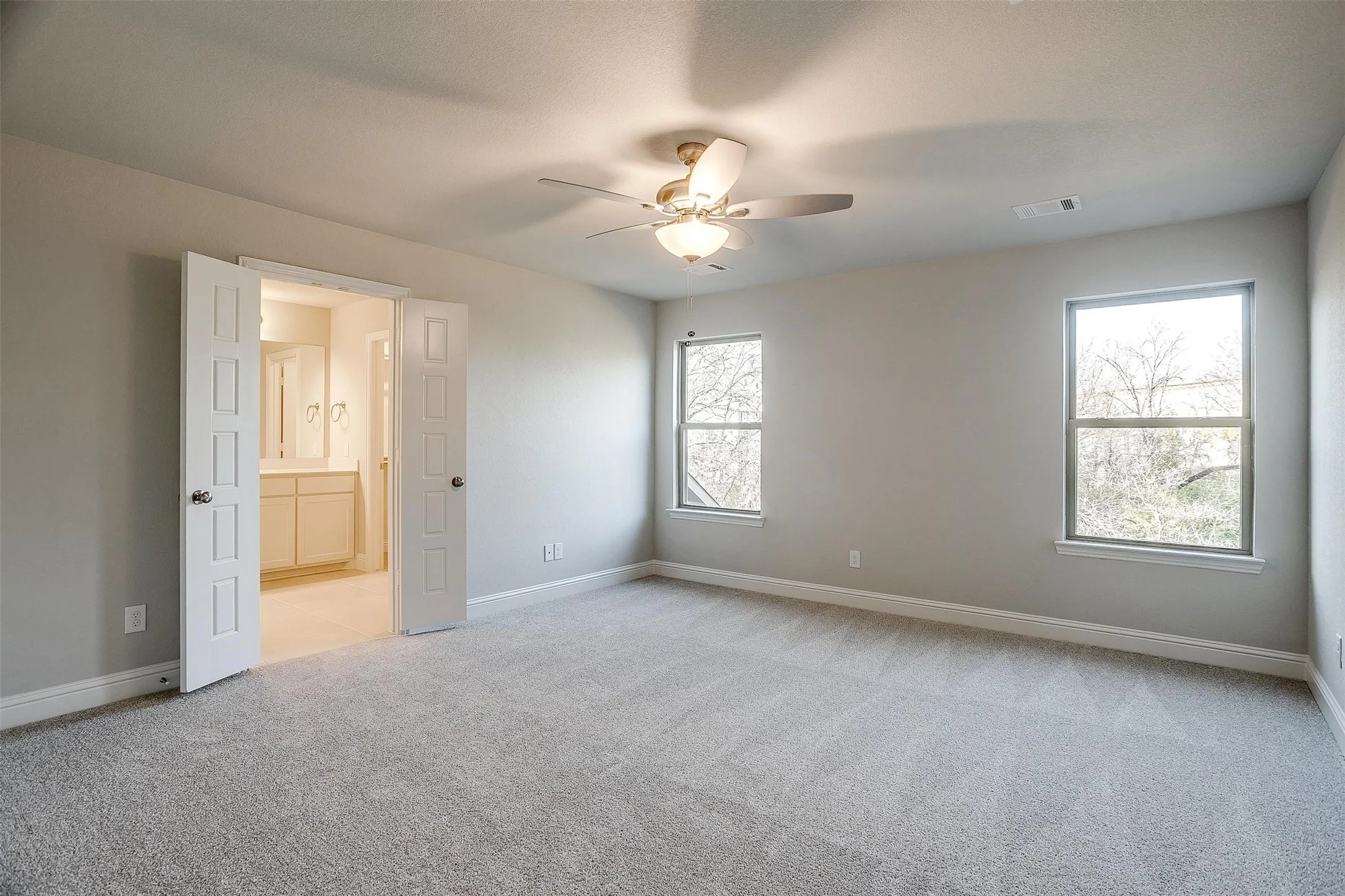Spacious room with light gray wall paint and gray carpeting