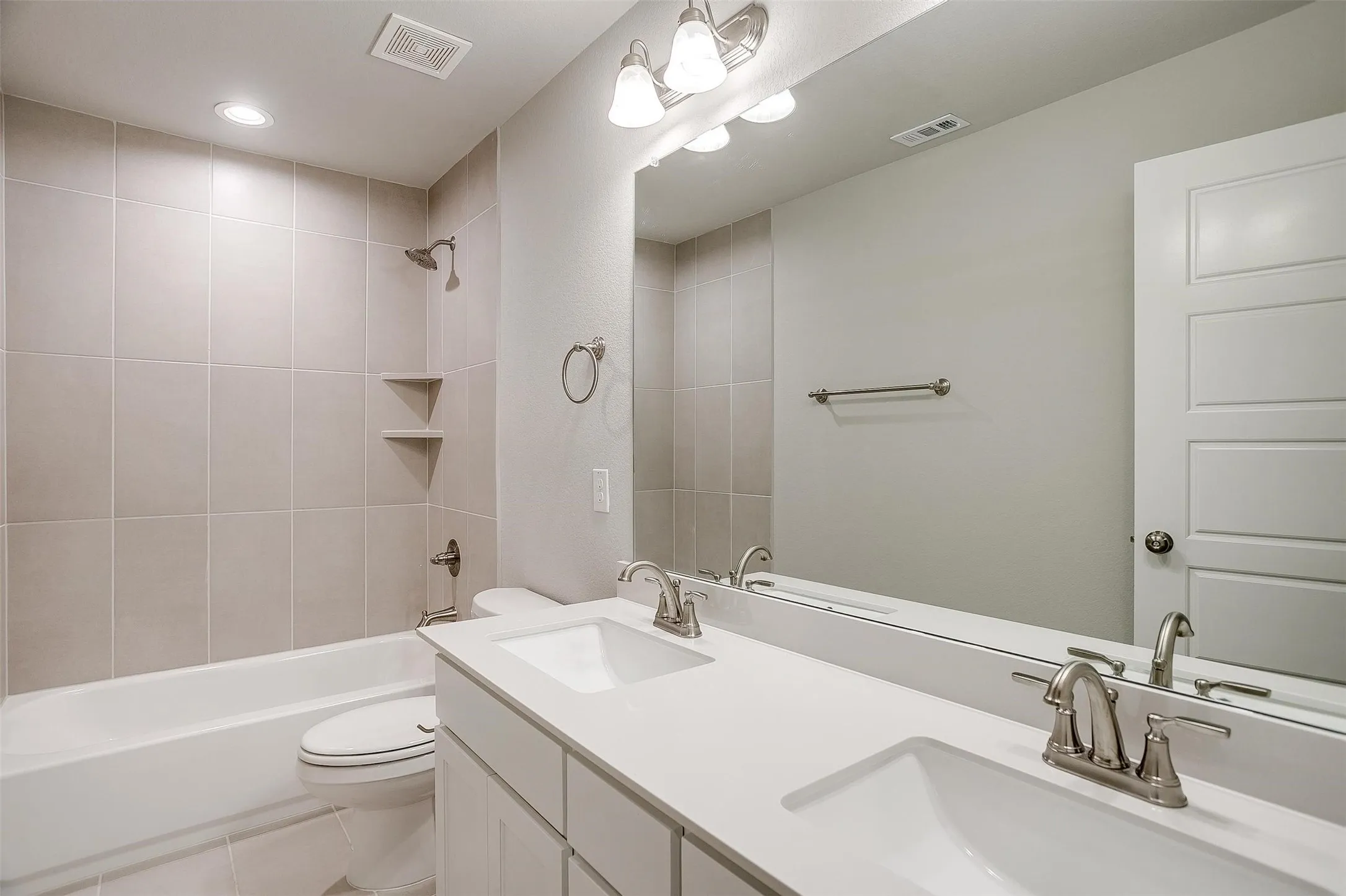 Dual vanity with undermount sinks, brushed nickel fixtures, and a spacious countertop
