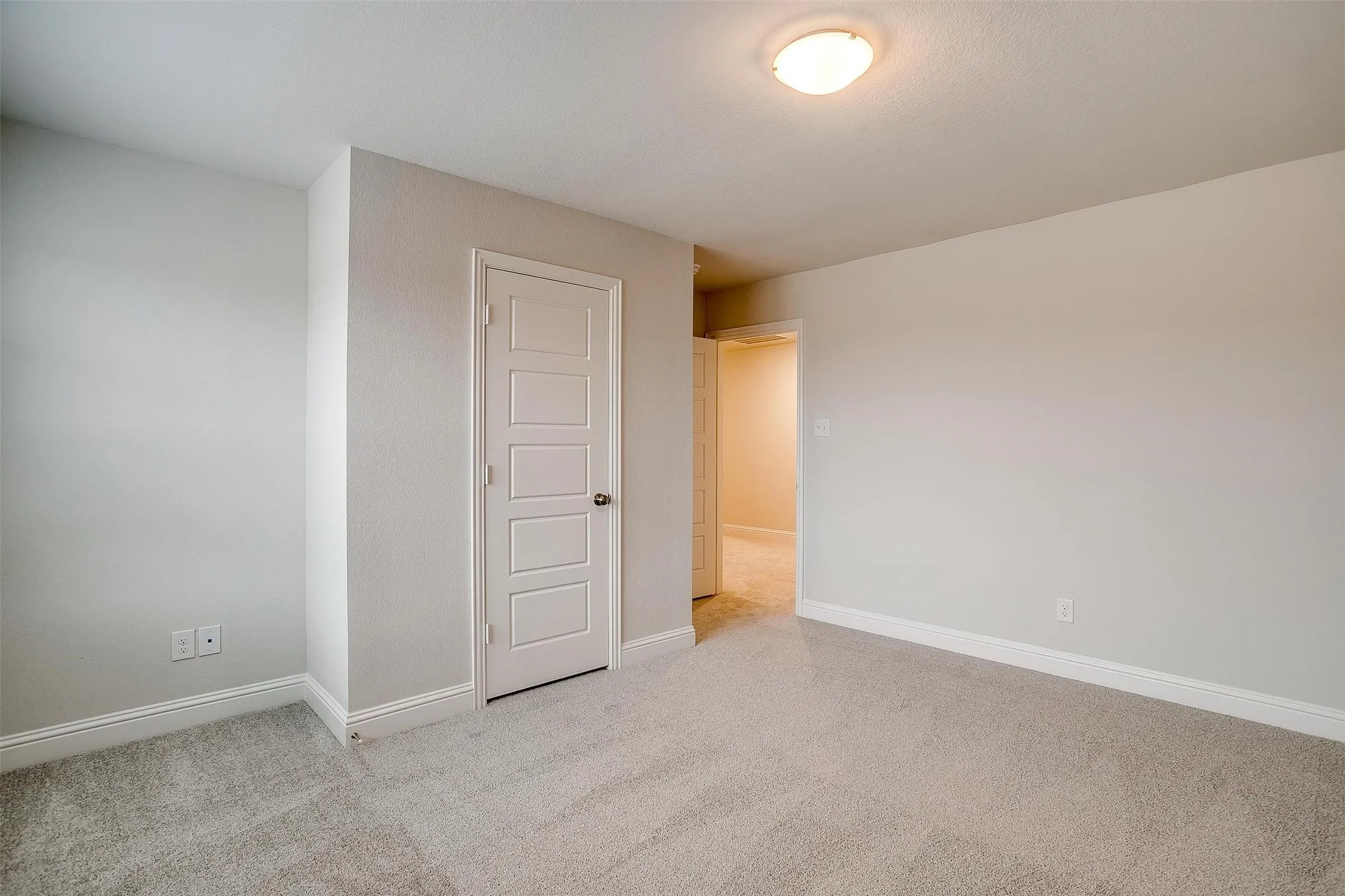 Neutral-toned walls, recessed lighting, and soft carpeting