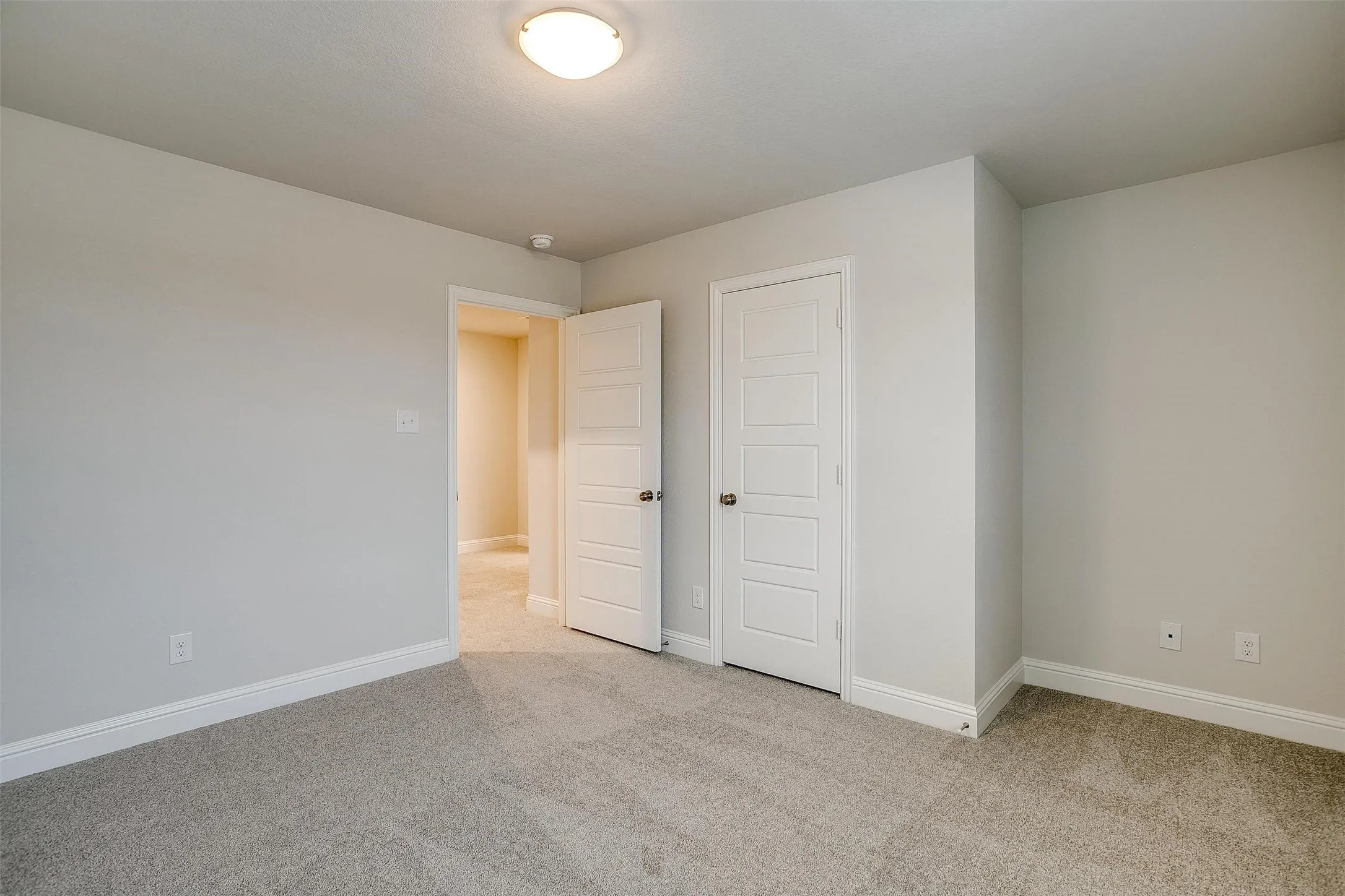 Neutral wall paint, light gray carpeting, flush mount ceiling light fixture, and white interior doors