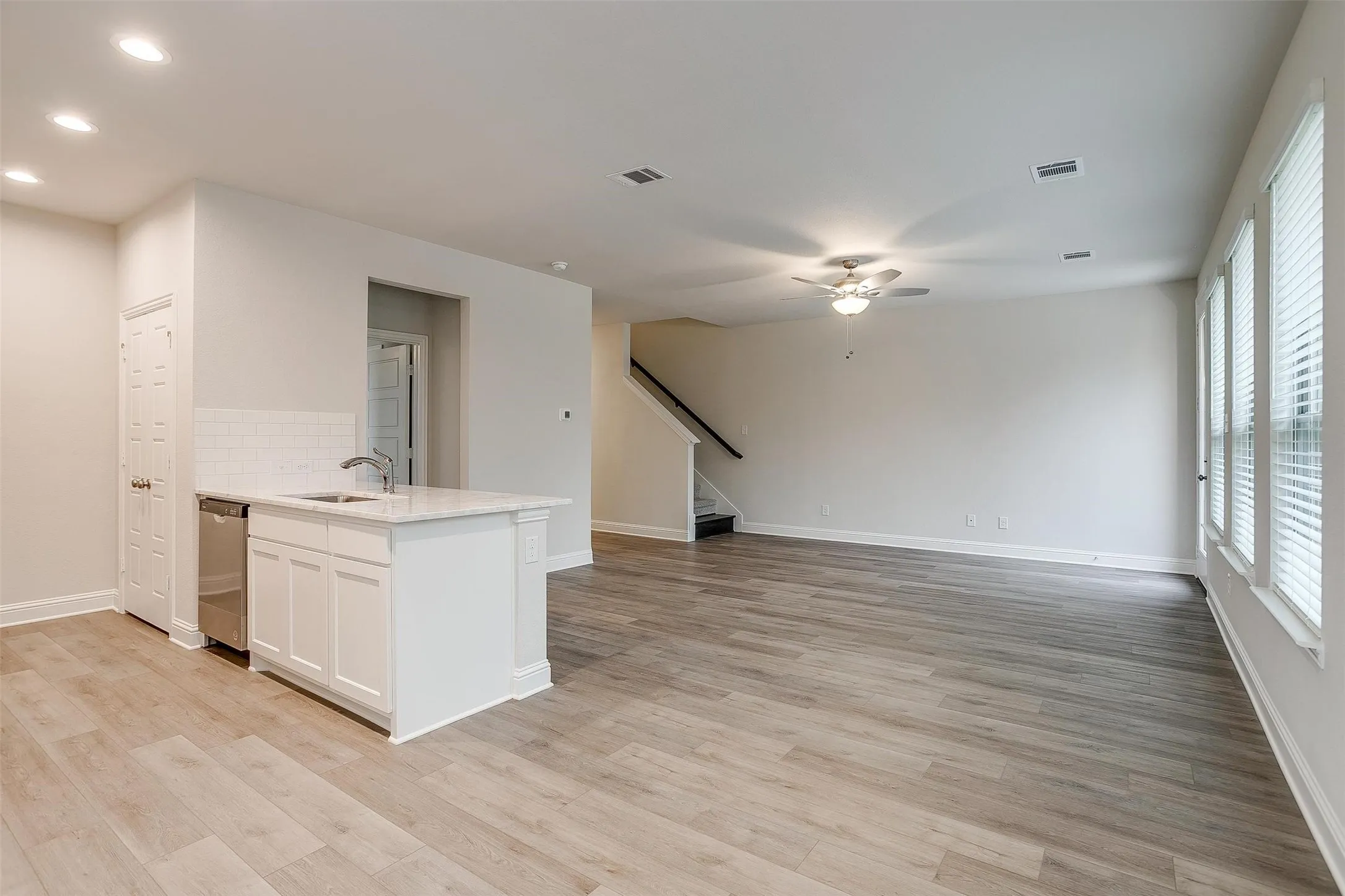 Open-concept living area featuring wood-finish flooring, recessed lighting, and a ceiling fan