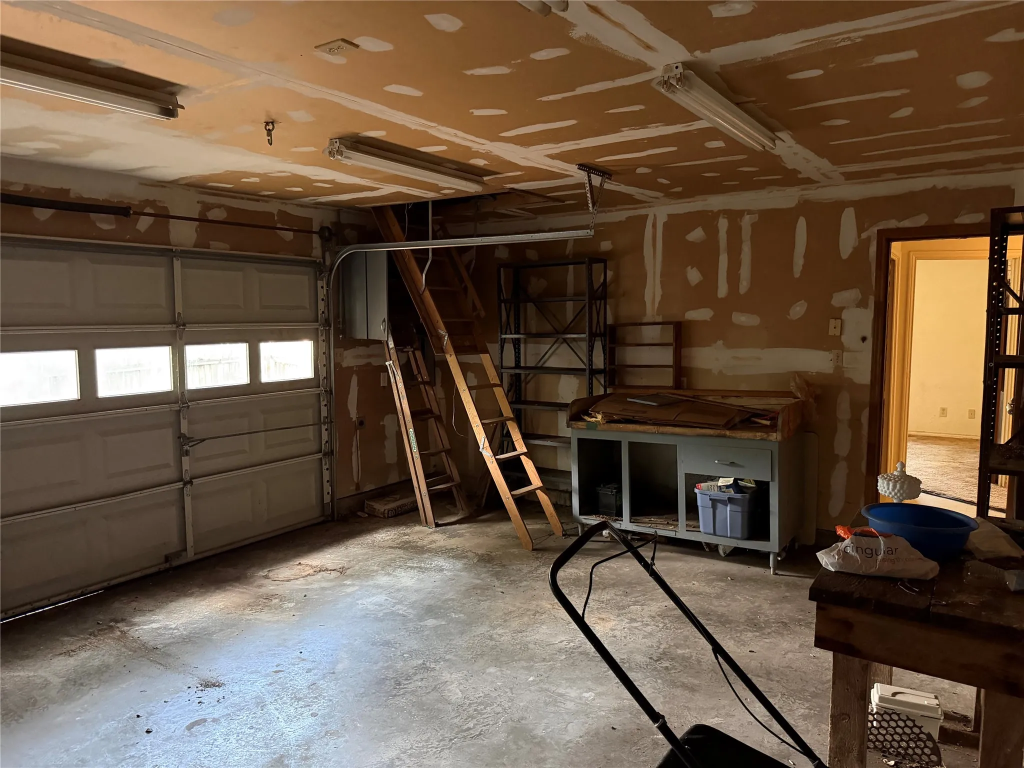 Attached garage with a panel garage door featuring window inserts