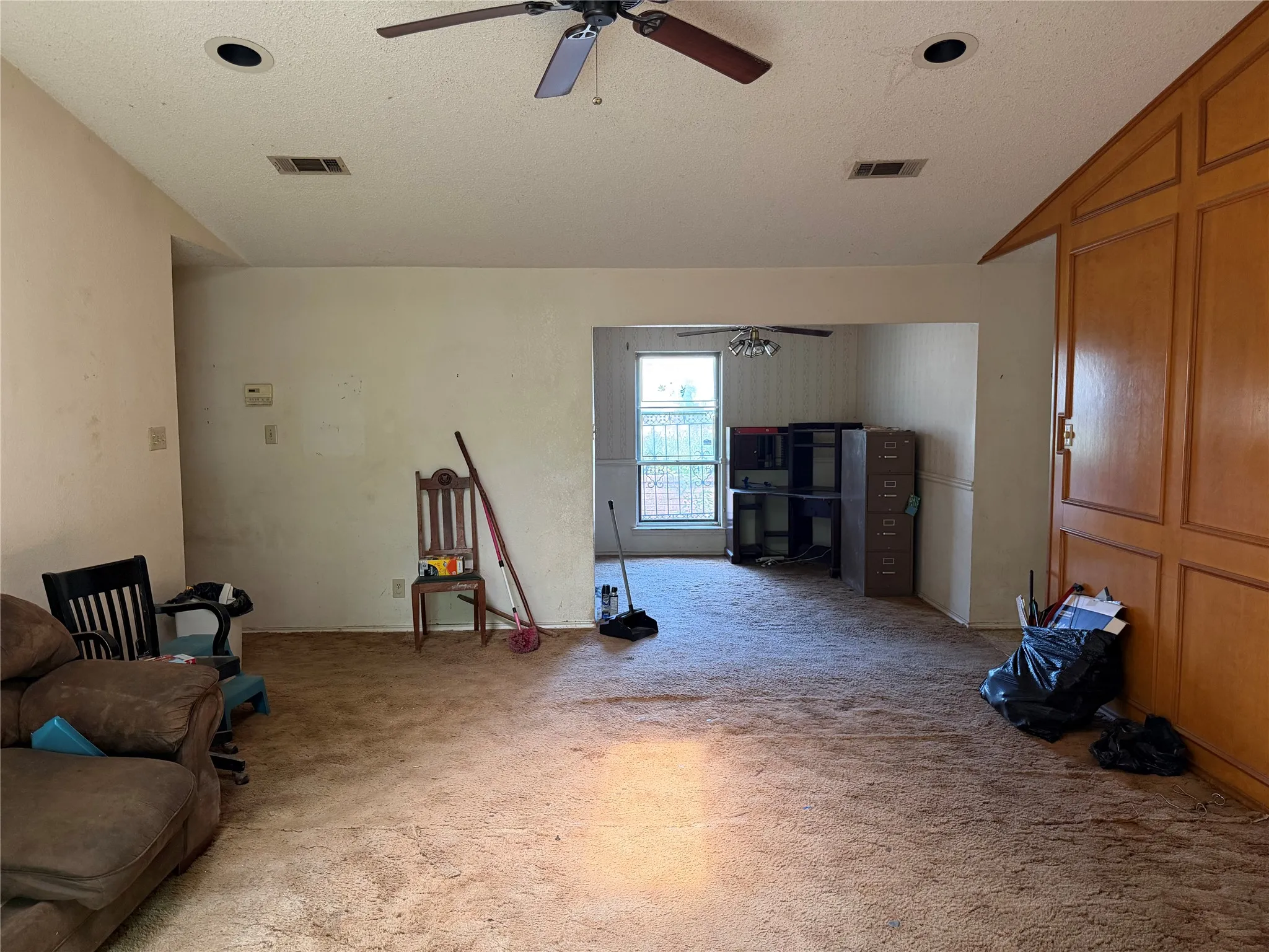 Recessed lighting, ceiling fan, wood-paneled wall, interior window, and carpet flooring