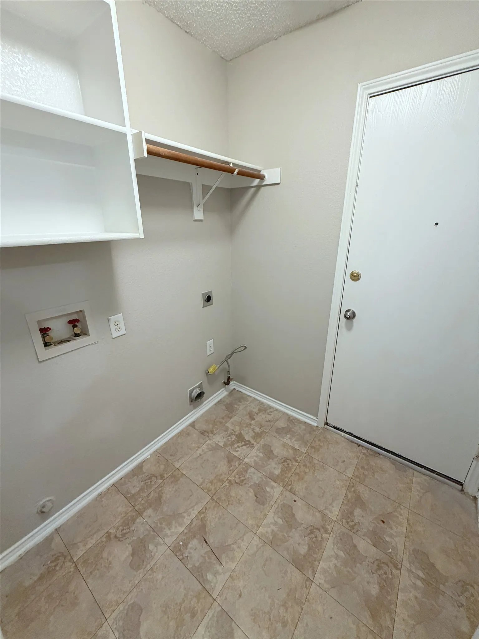 Tiled flooring, white built-in shelving, and a wood hanging rod