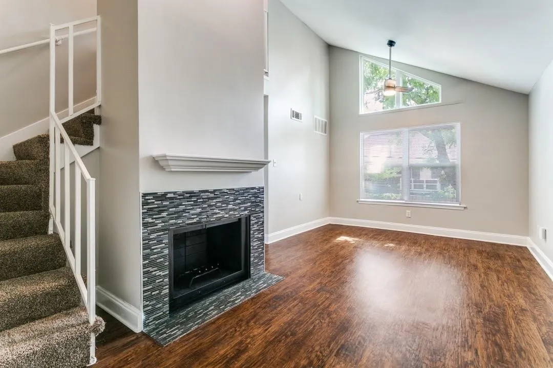 Wood-finish flooring with an accent fireplace featuring mosaic tile surround and mantel