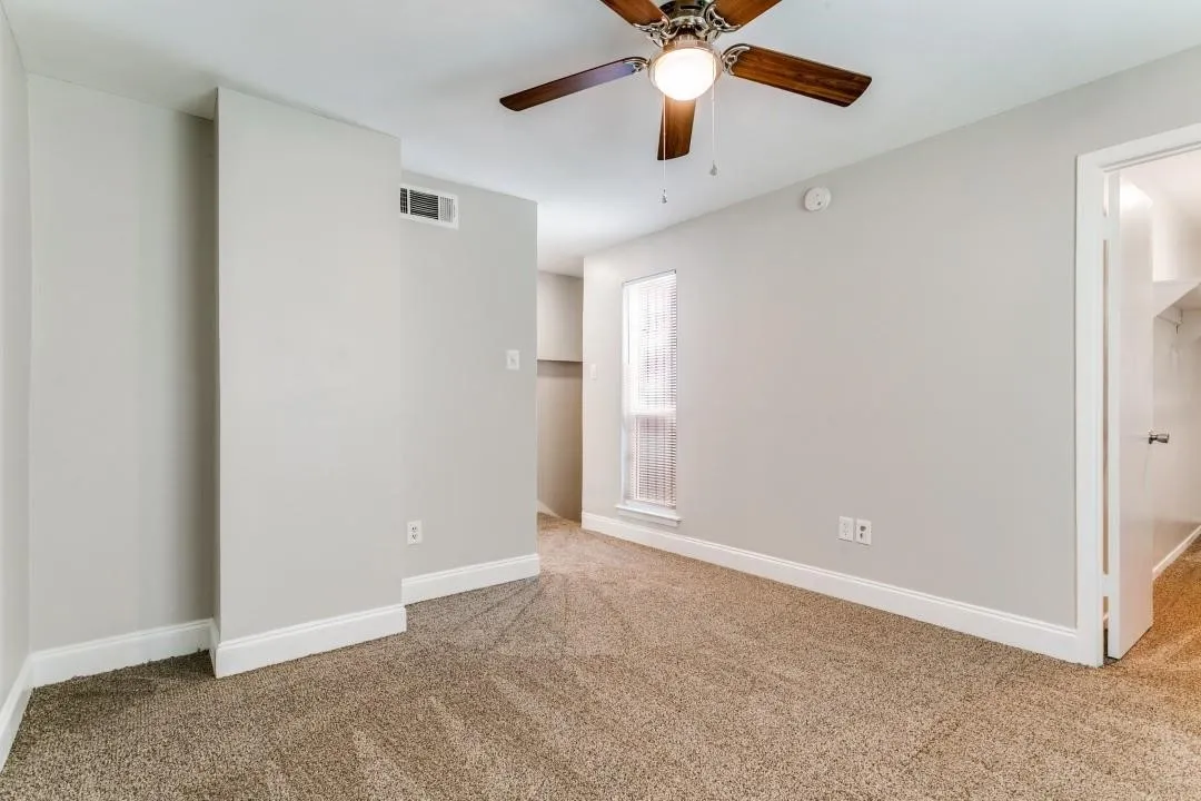 Neutral-toned carpeting, light gray wall paint, and white trim accents