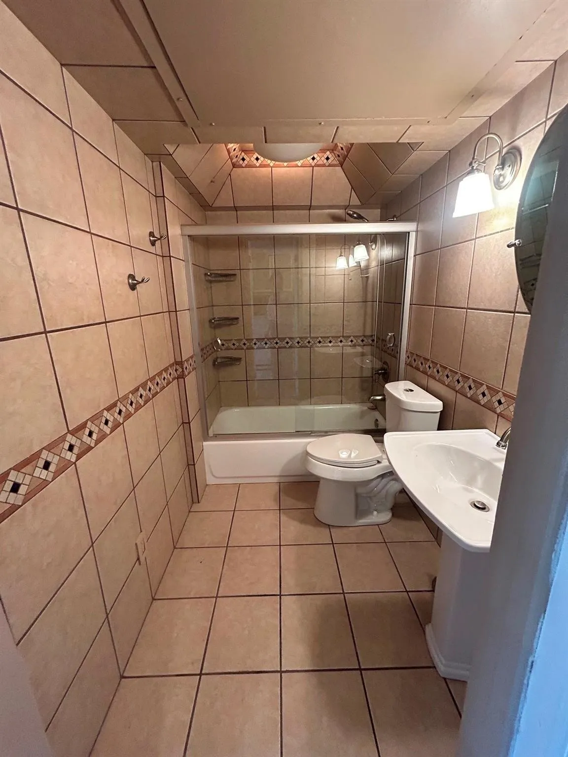 Tile flooring and walls featuring a decorative tile border