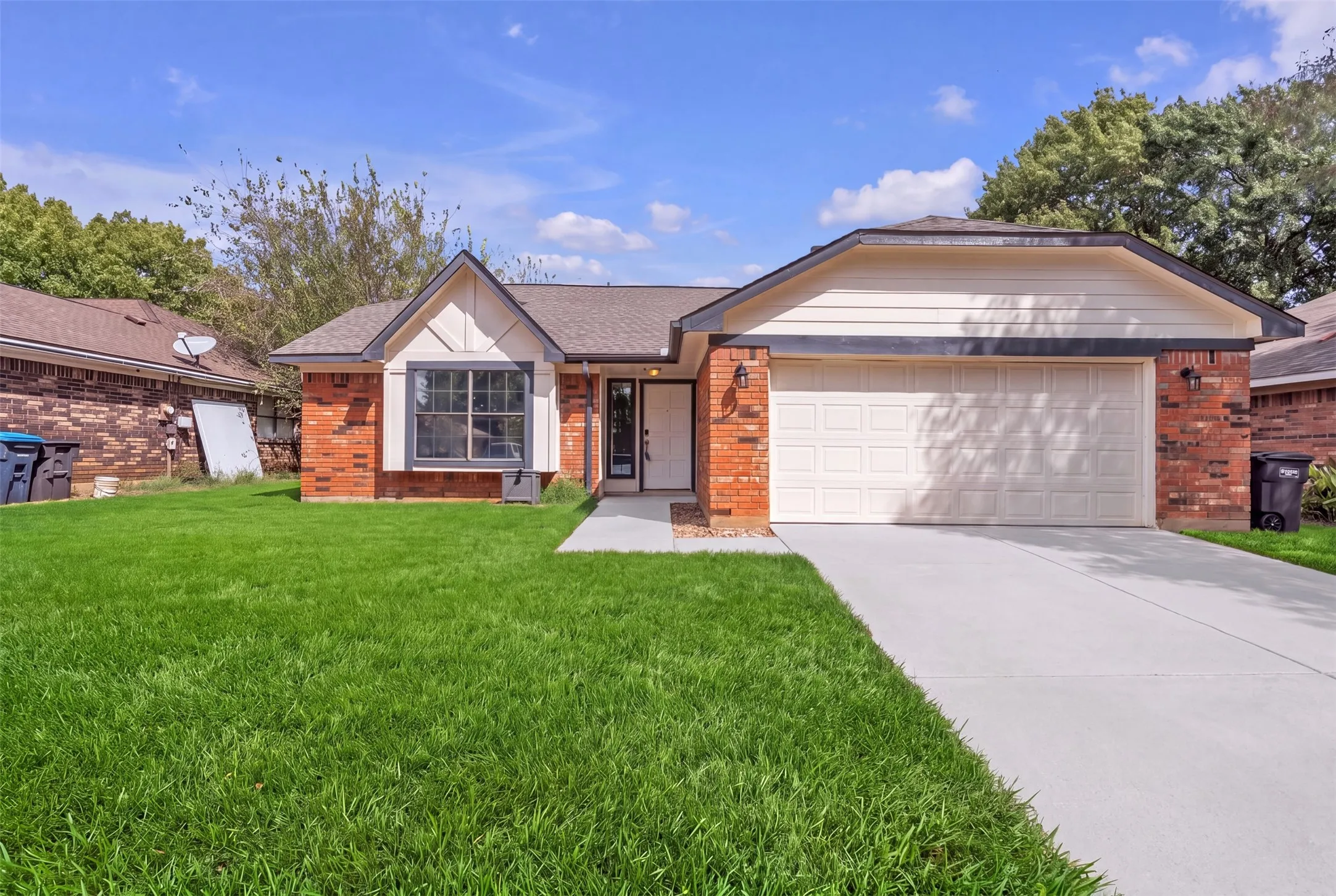 Brick and siding exterior with a gabled roof. Grass is digitally enhanced