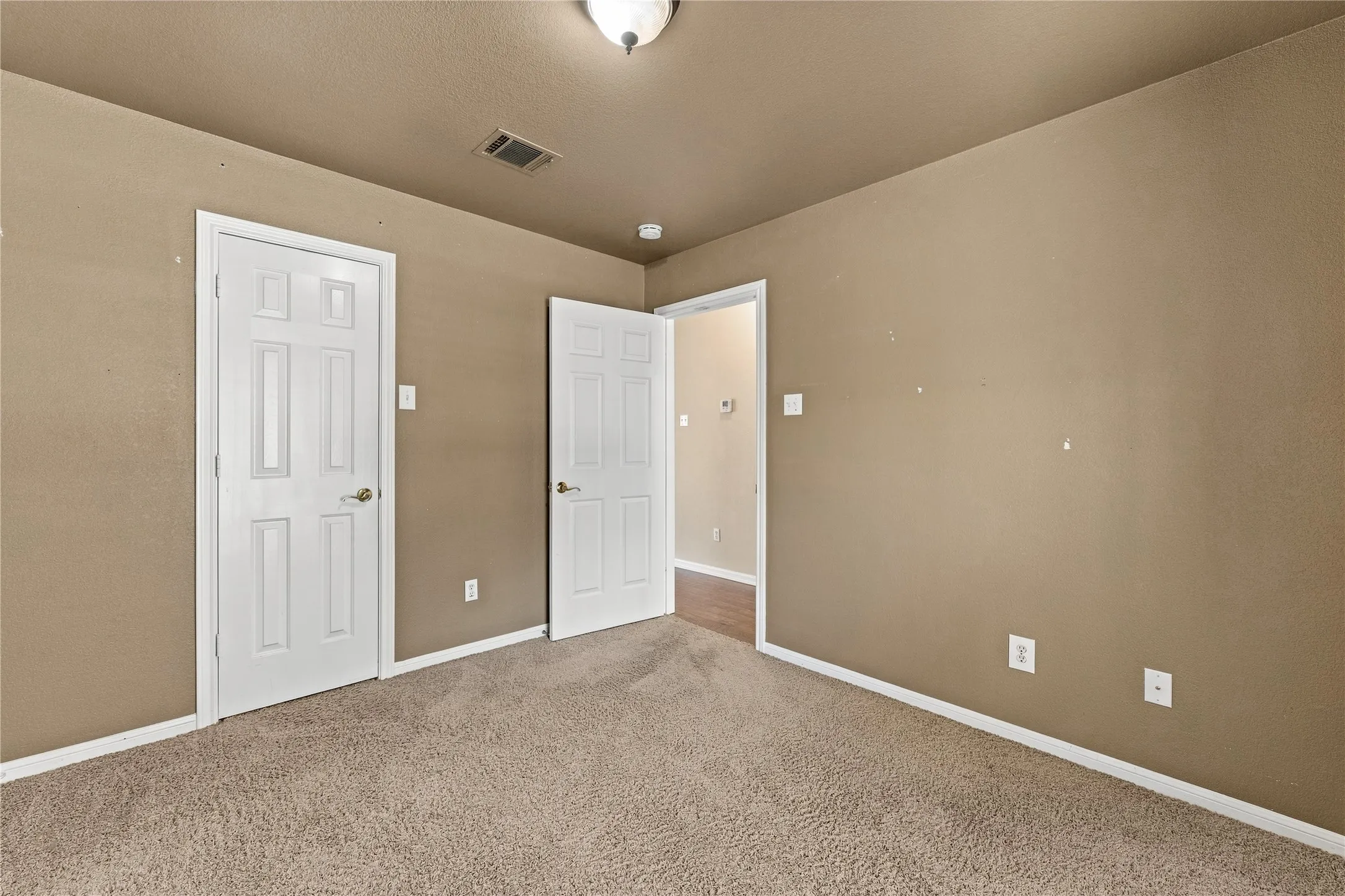 Carpeted flooring, neutral wall tones, white trim, and white paneled doors