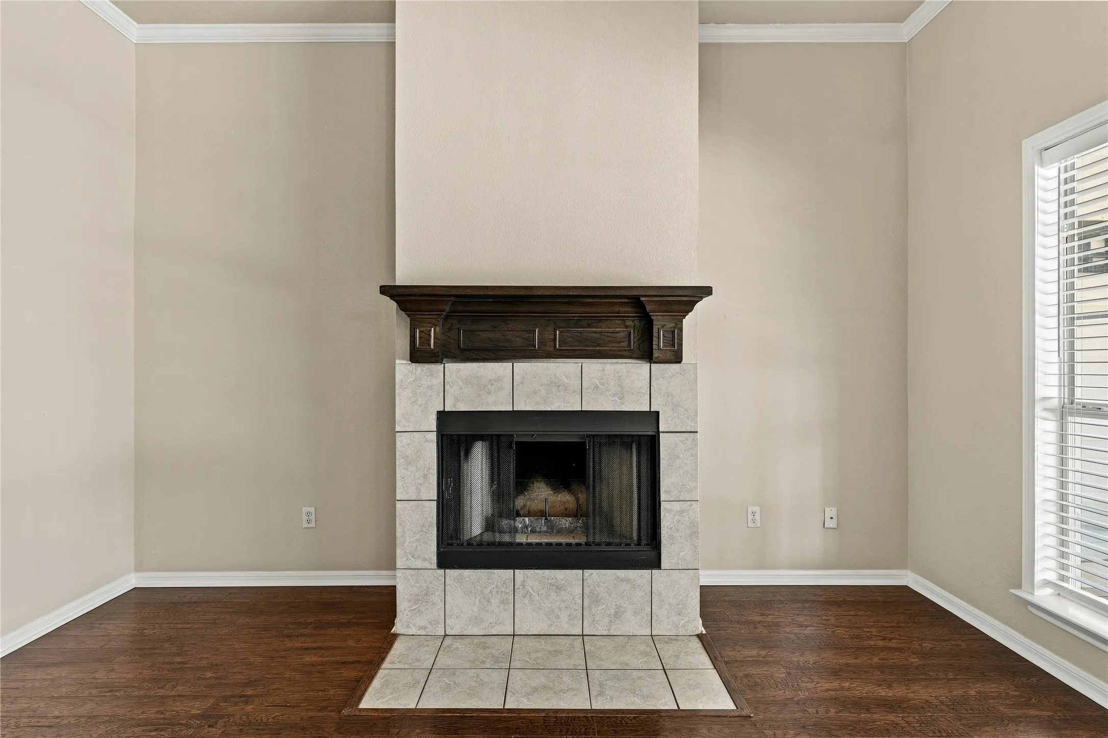 Fireplace featuring a tile surround, dark wood mantel, and a firebox