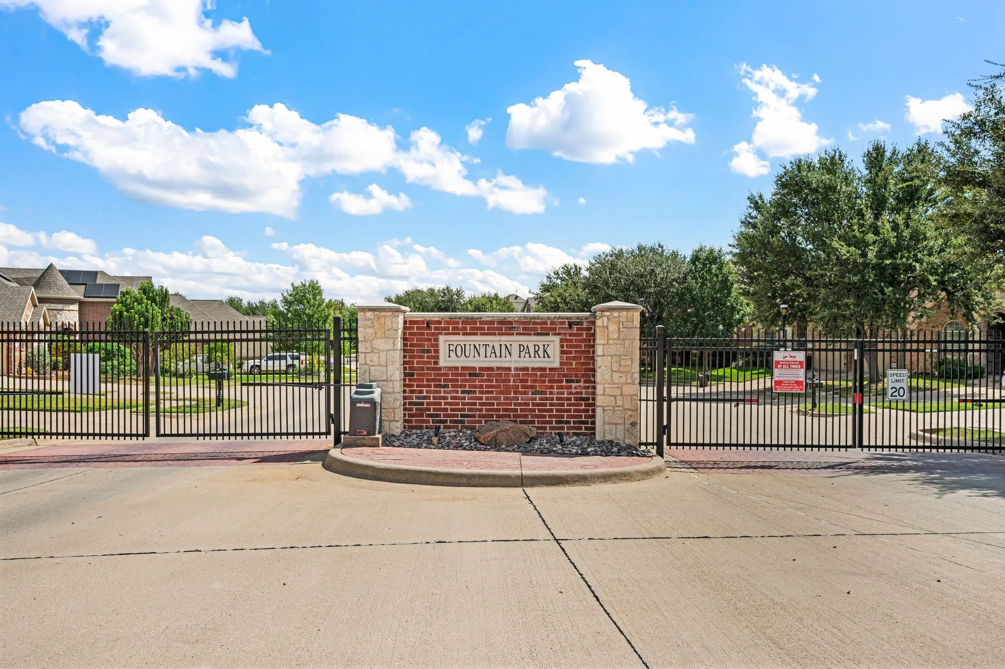 Gated community entrance with brick and stone pillar signage