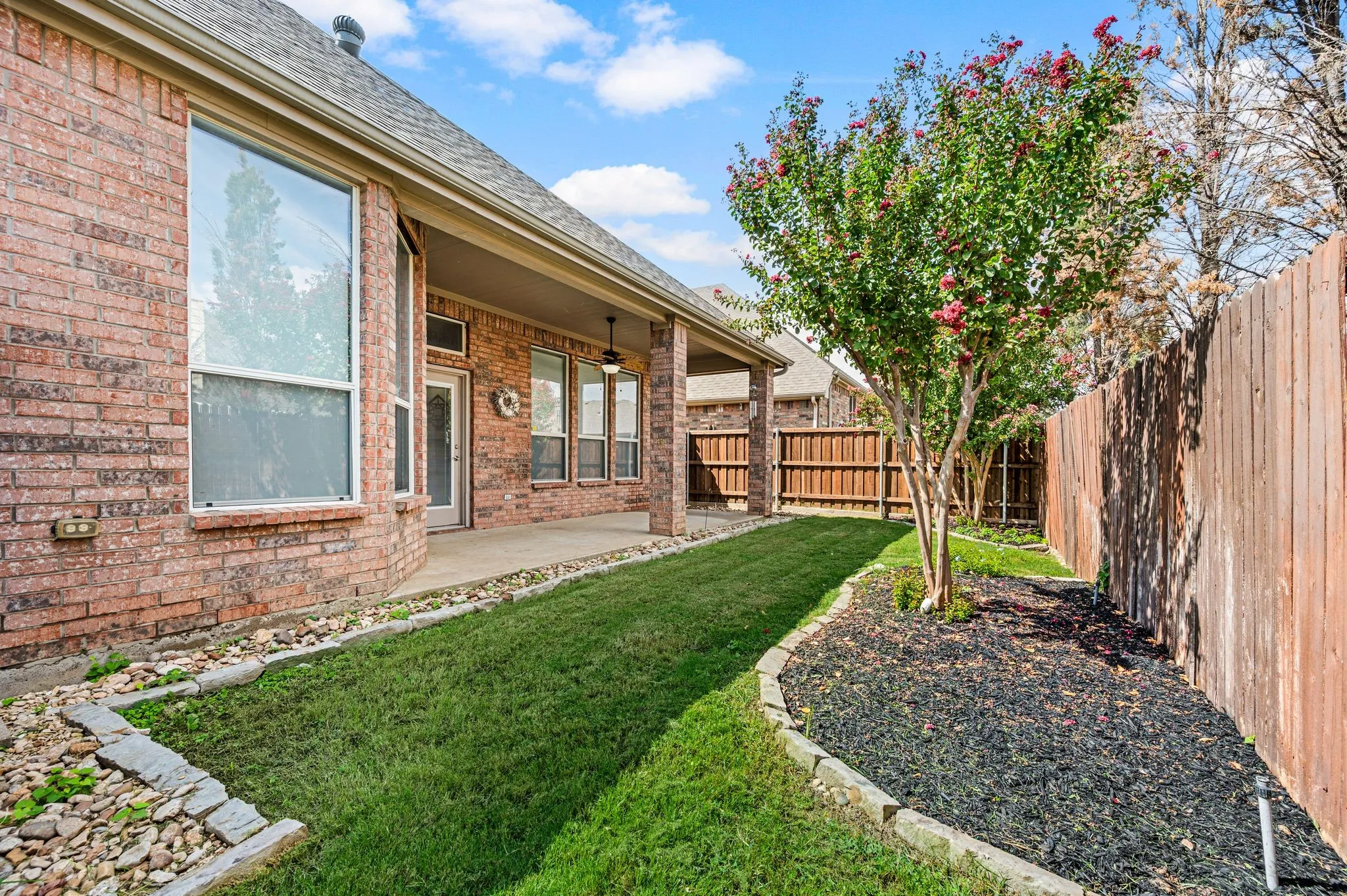 Brick exterior with multiple windows and a covered patio