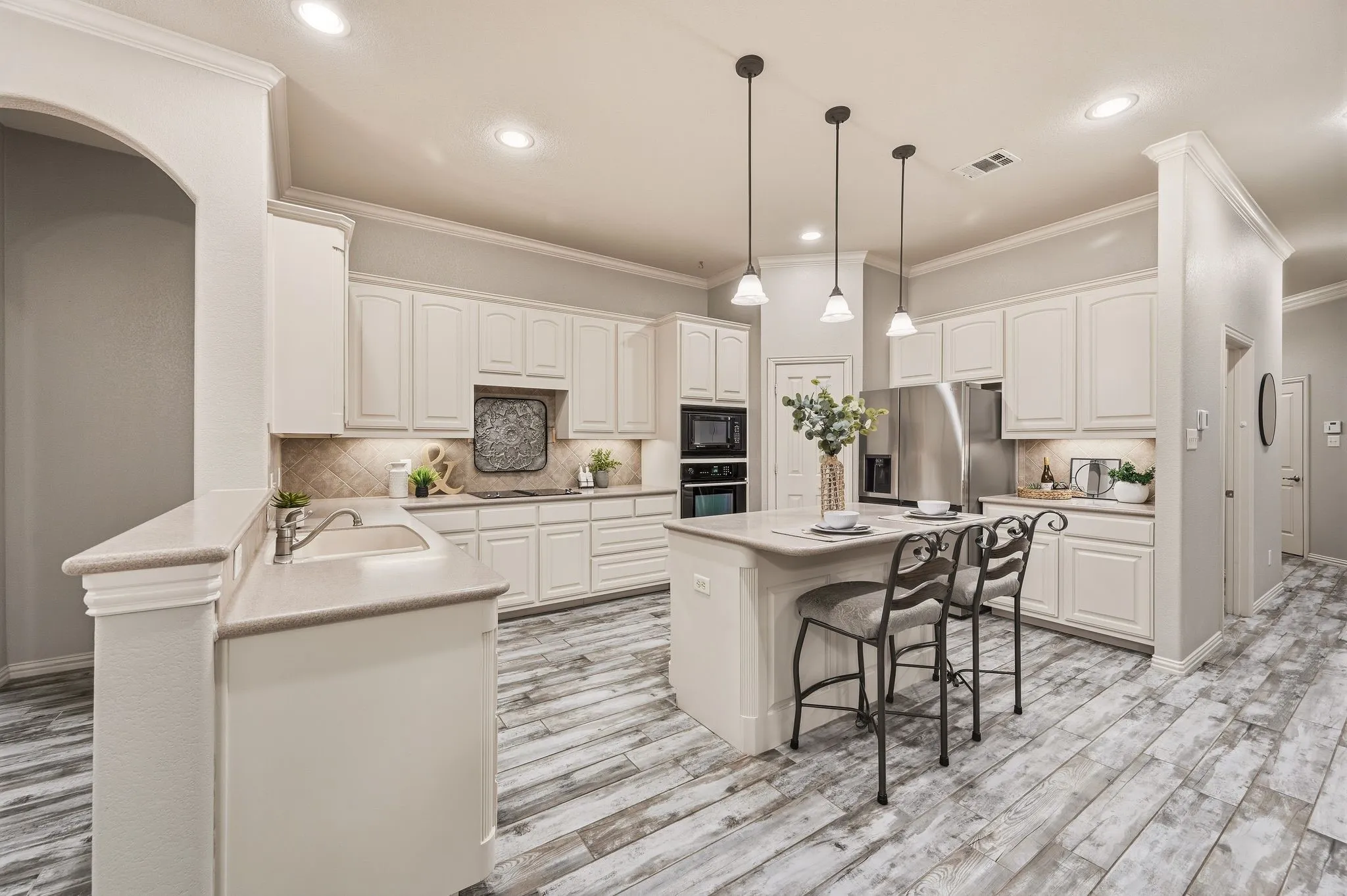 Kitchen with white cabinetry, light countertops, wood-finish flooring, recessed lighting, and a kitchen island with pendant lighting