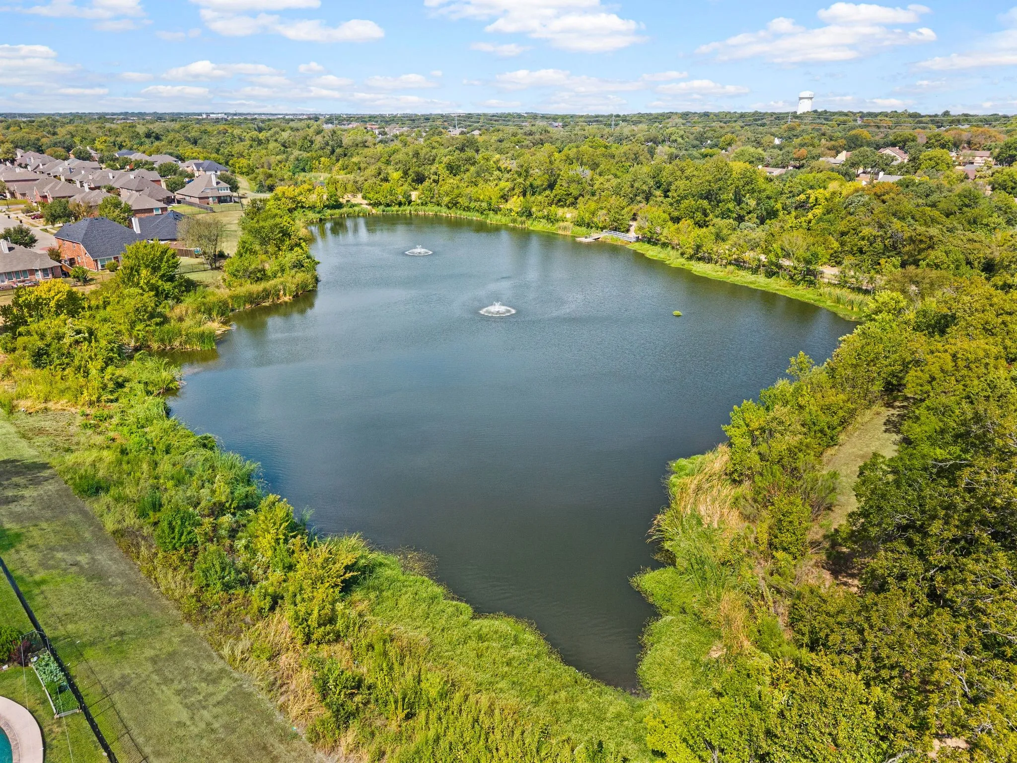 Community pond with established landscaping and two water features