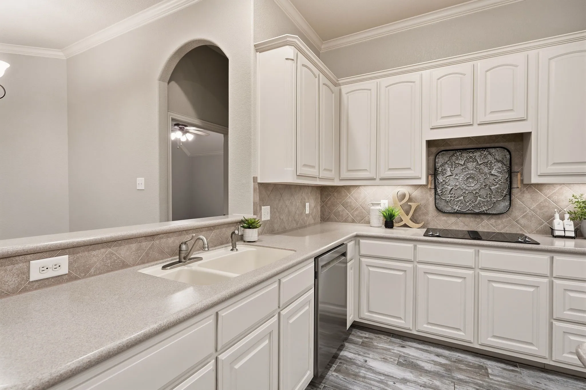 White cabinetry with brushed nickel hardware, light-toned countertops, and a tiled backsplash