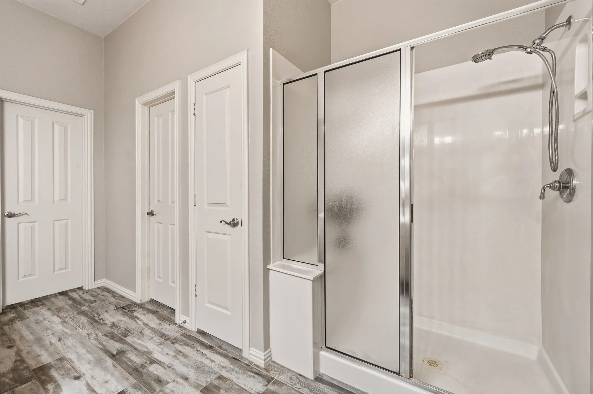Walk-in shower with a frosted glass enclosure and a built-in shelf