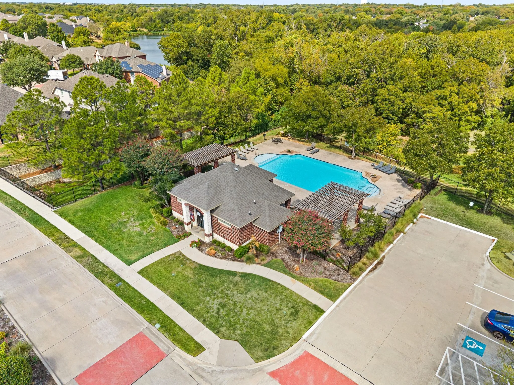 Community Pool with brick exterior, gabled roof, and adjacent swimming pool