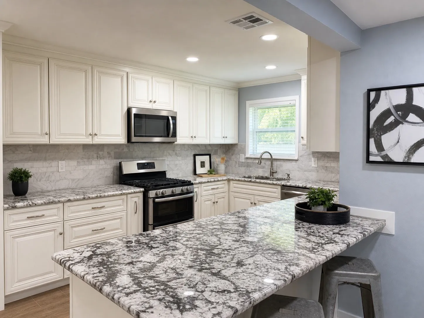 Spacious kitchen featuring an extended peninsula, stainless steel appliances, upper and lower cabinetry, recessed lighting, and a window above the sink