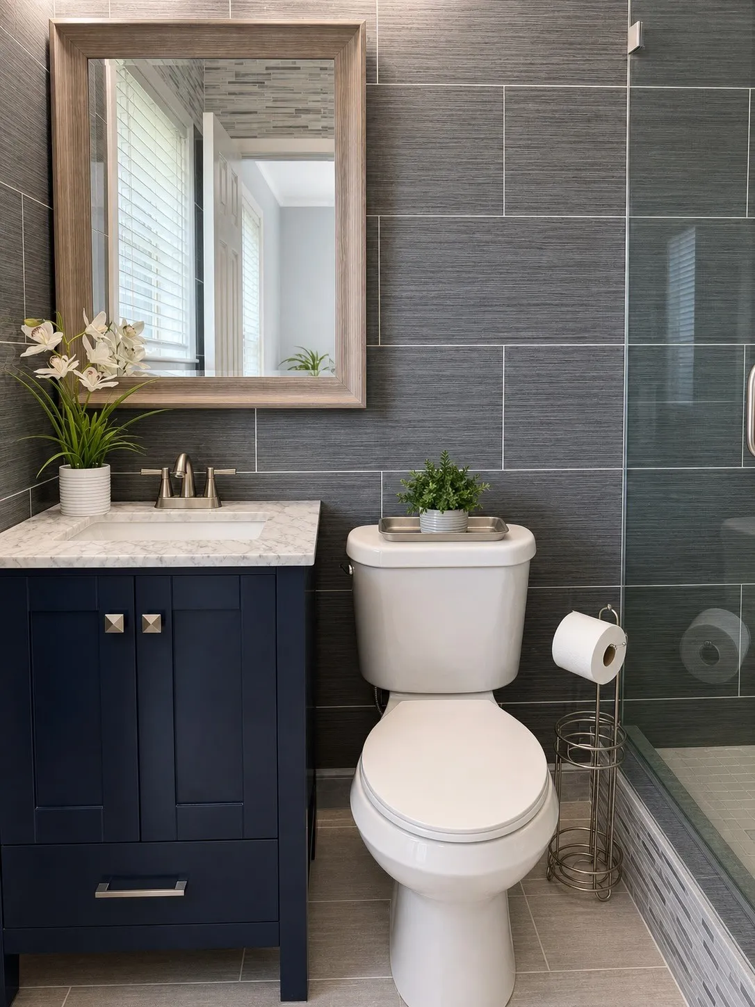 Vanity with a marble-finish countertop and undermount sink, framed mirror, and rectangular gray wall tiling