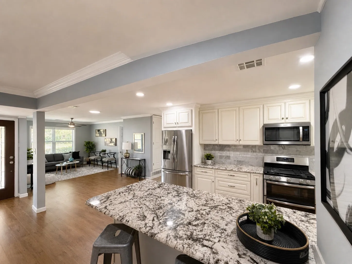 Kitchen featuring an island with stone countertop, stainless steel appliances, and cream cabinetry