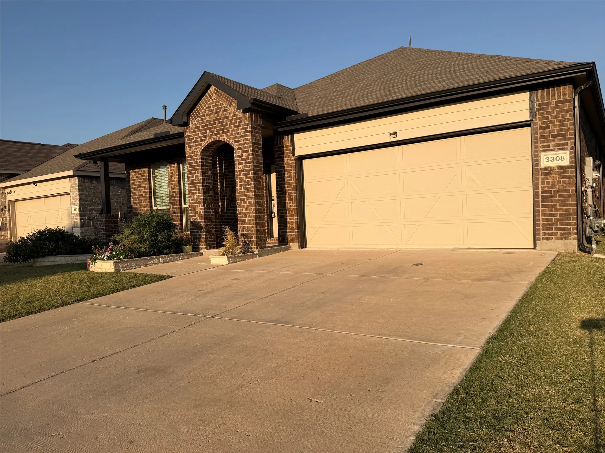 Brick exterior with a prominent arched entrance and a two-car garage