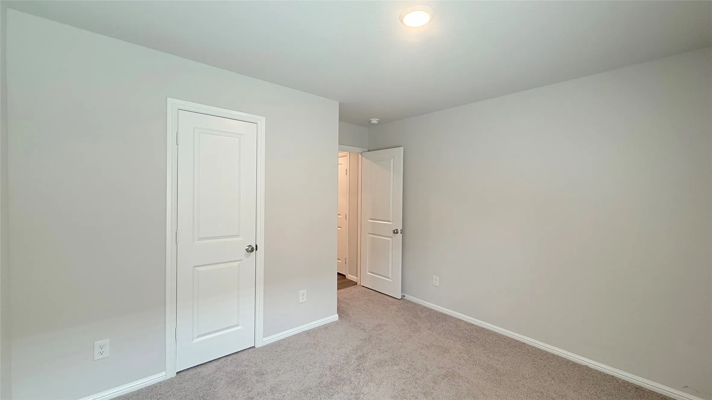 Recessed ceiling lighting, light gray wall finish, white trim, and light-colored carpeting