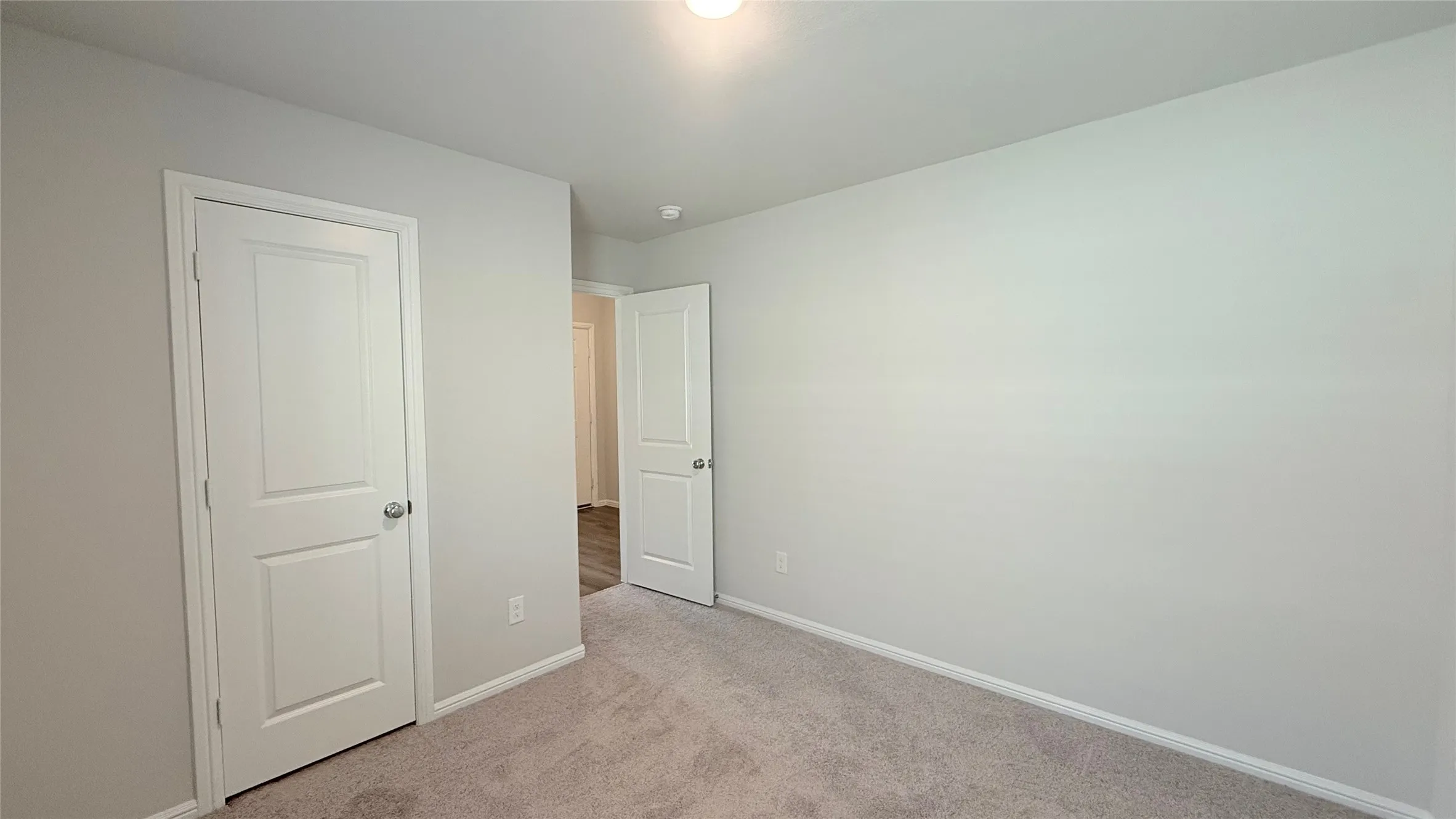 Carpeted flooring, light neutral wall paint, and white trim