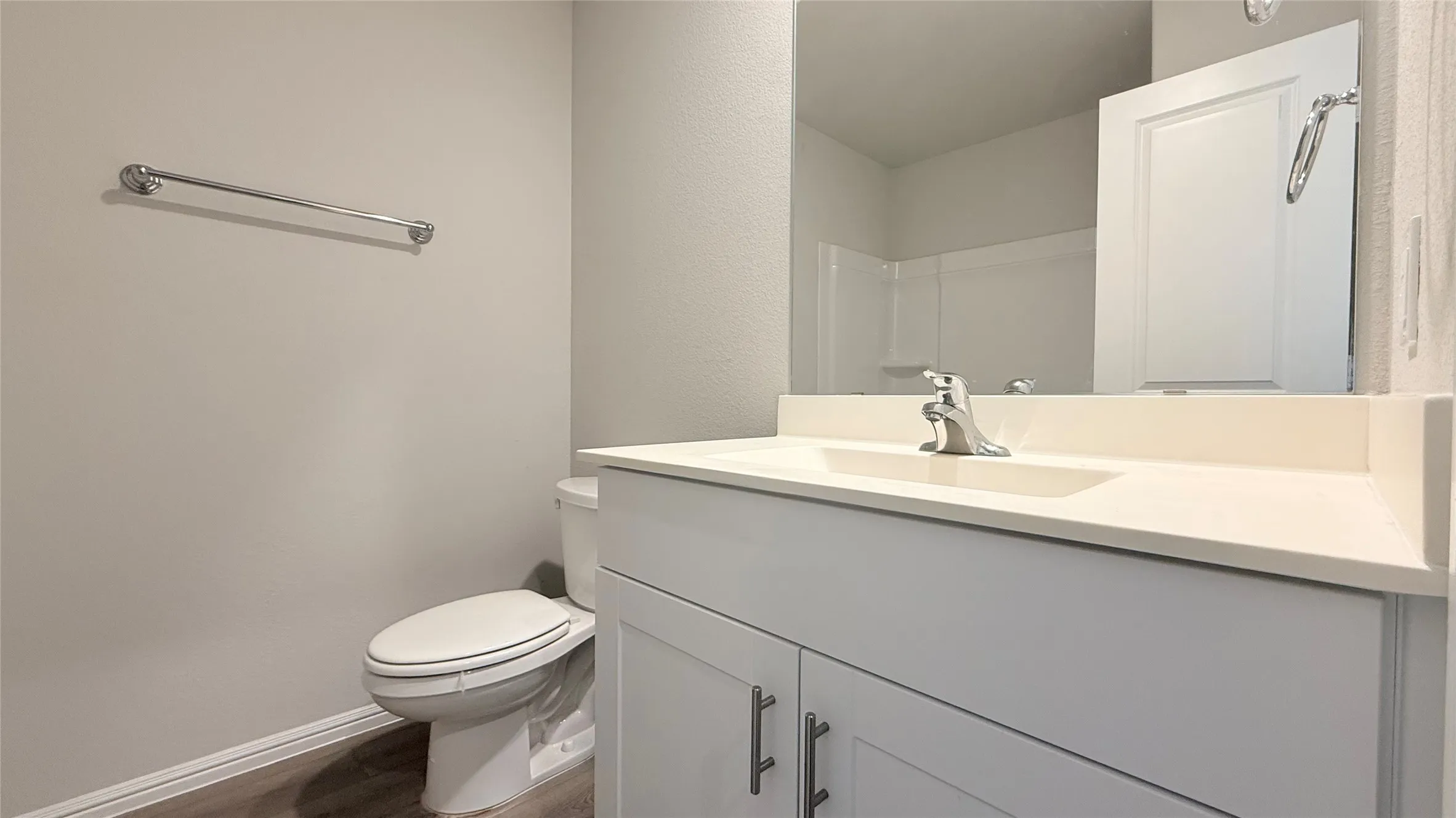 White vanity with a built-in rectangular sink, chrome faucet, and integrated countertop