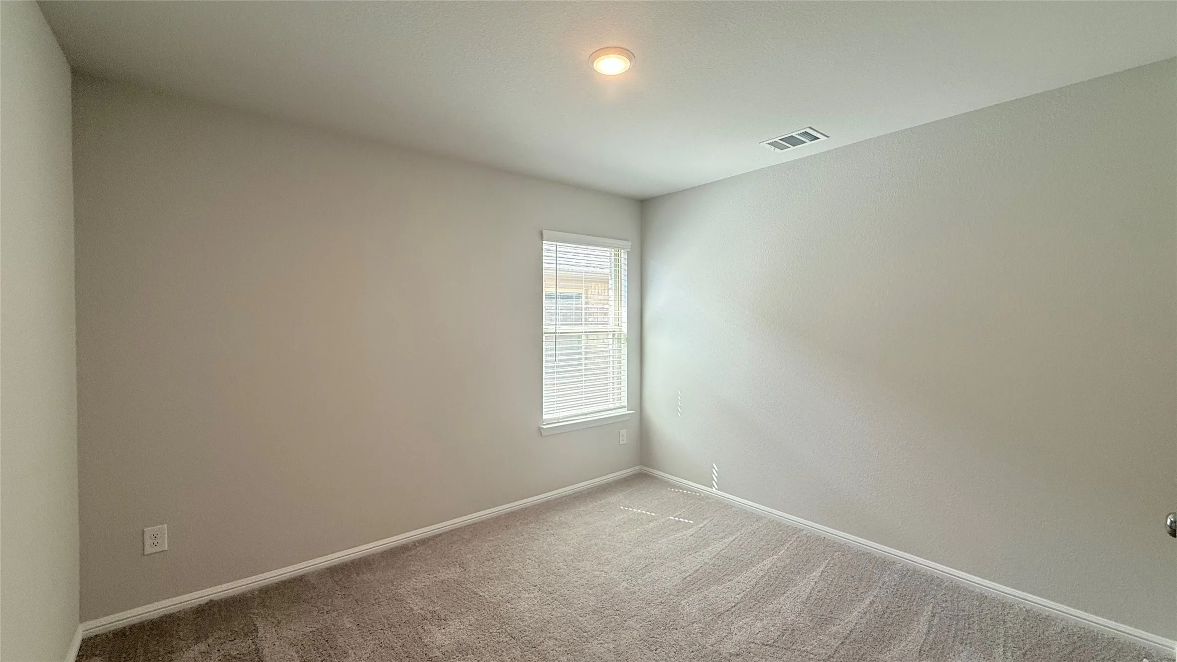 Recessed ceiling lighting, textured wall finish, window with horizontal blinds, and carpeted flooring