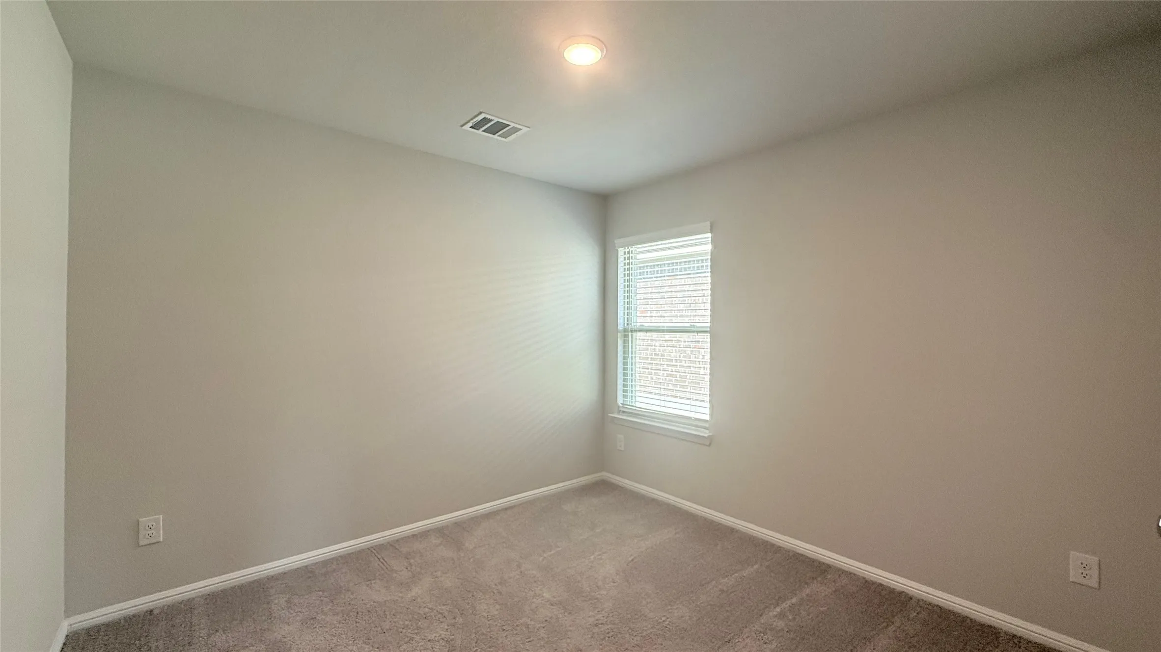 Carpeted flooring, neutral wall paint, recessed lighting, and a single window with blinds