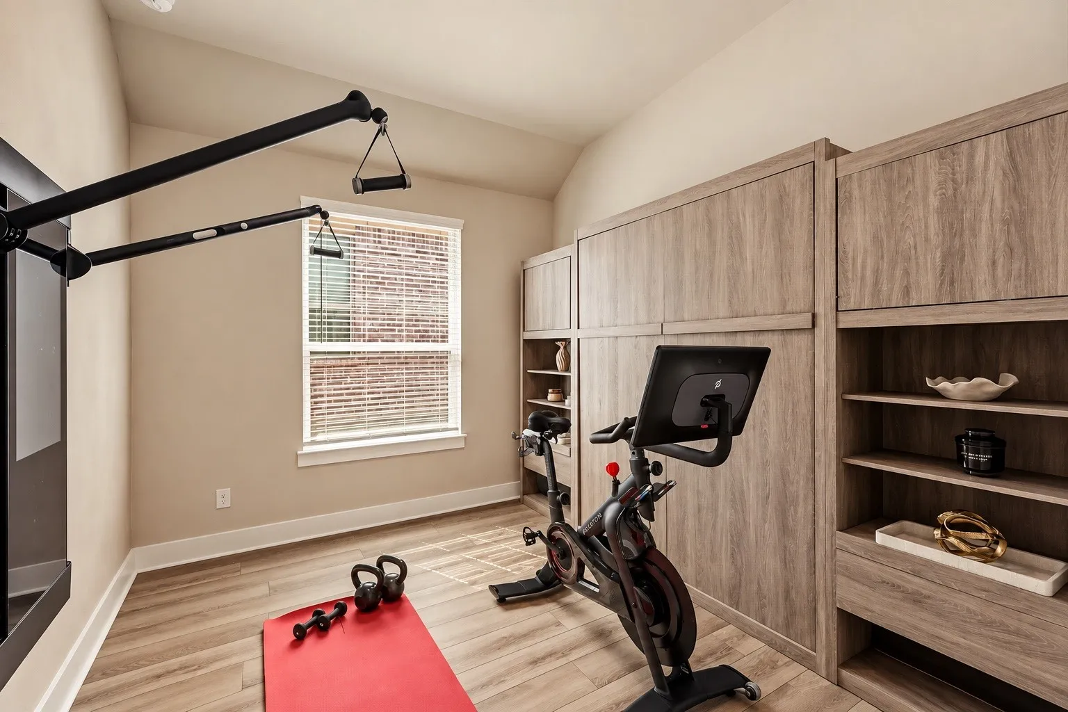 Secondary Bedroom 3 shown with the wall bed tucked away, transforming the space into a spacious and functional home gym while showcasing the room’s versatility.