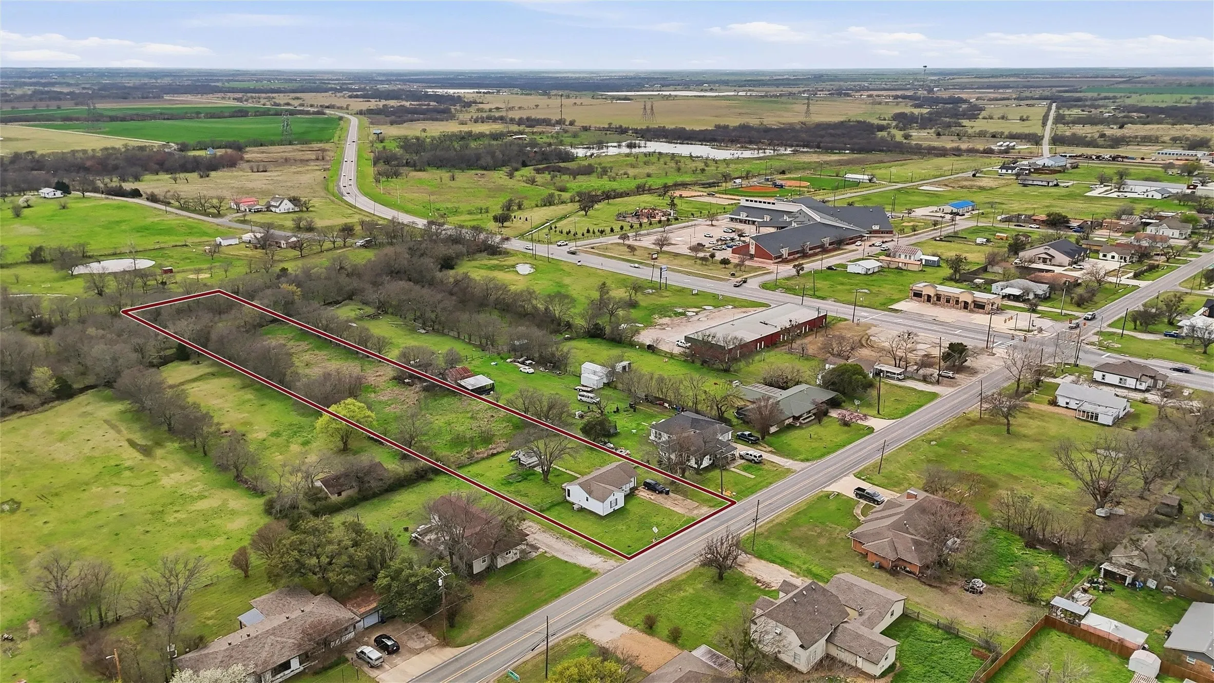 Expansive land parcel featuring open fields and mature trees