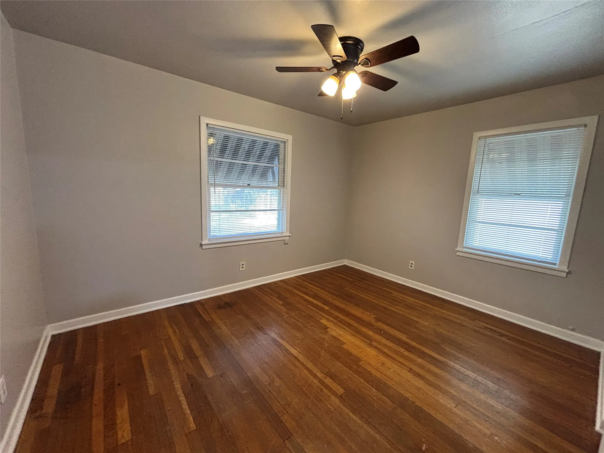 Hardwood flooring, painted walls, and a ceiling fan with integrated lighting