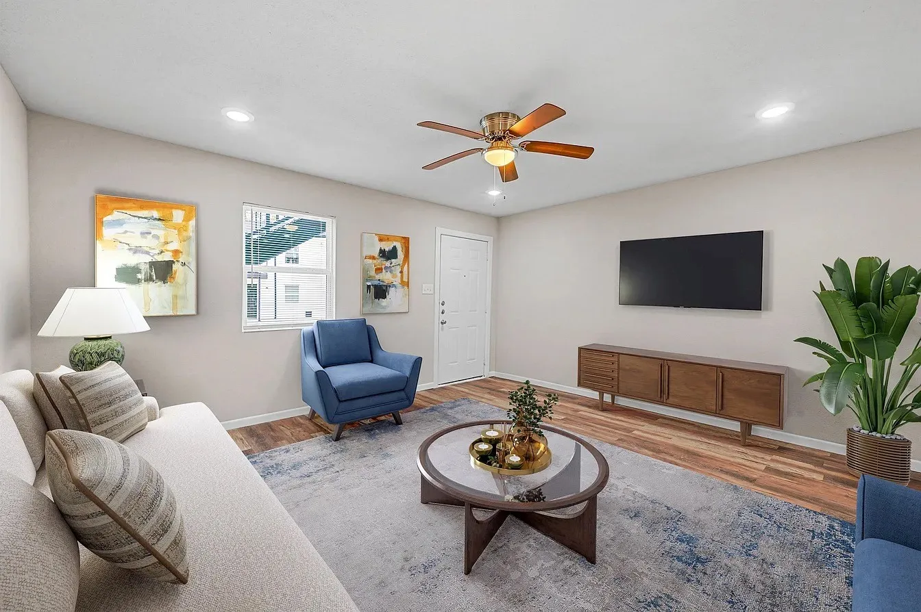 Spacious living area featuring wood-finish flooring, recessed lighting, and a ceiling fan with integrated lighting