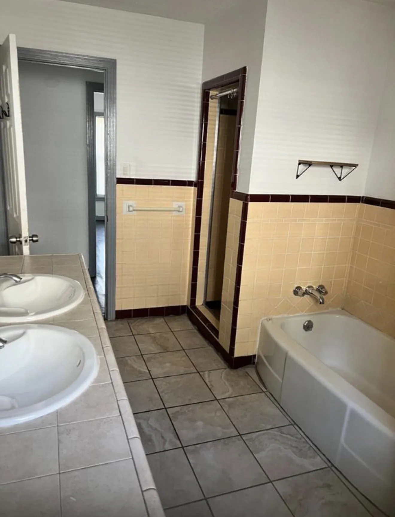 Spacious Double vanity with tiled countertop, floor-set bathtub, separate tiled shower, and tiled flooring