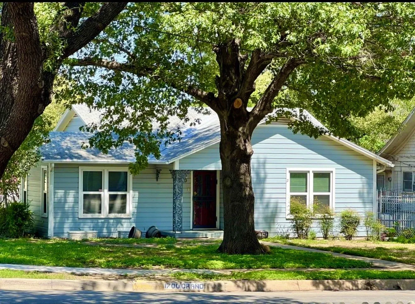 Adorable light blue home with white trim and decorative metal columns